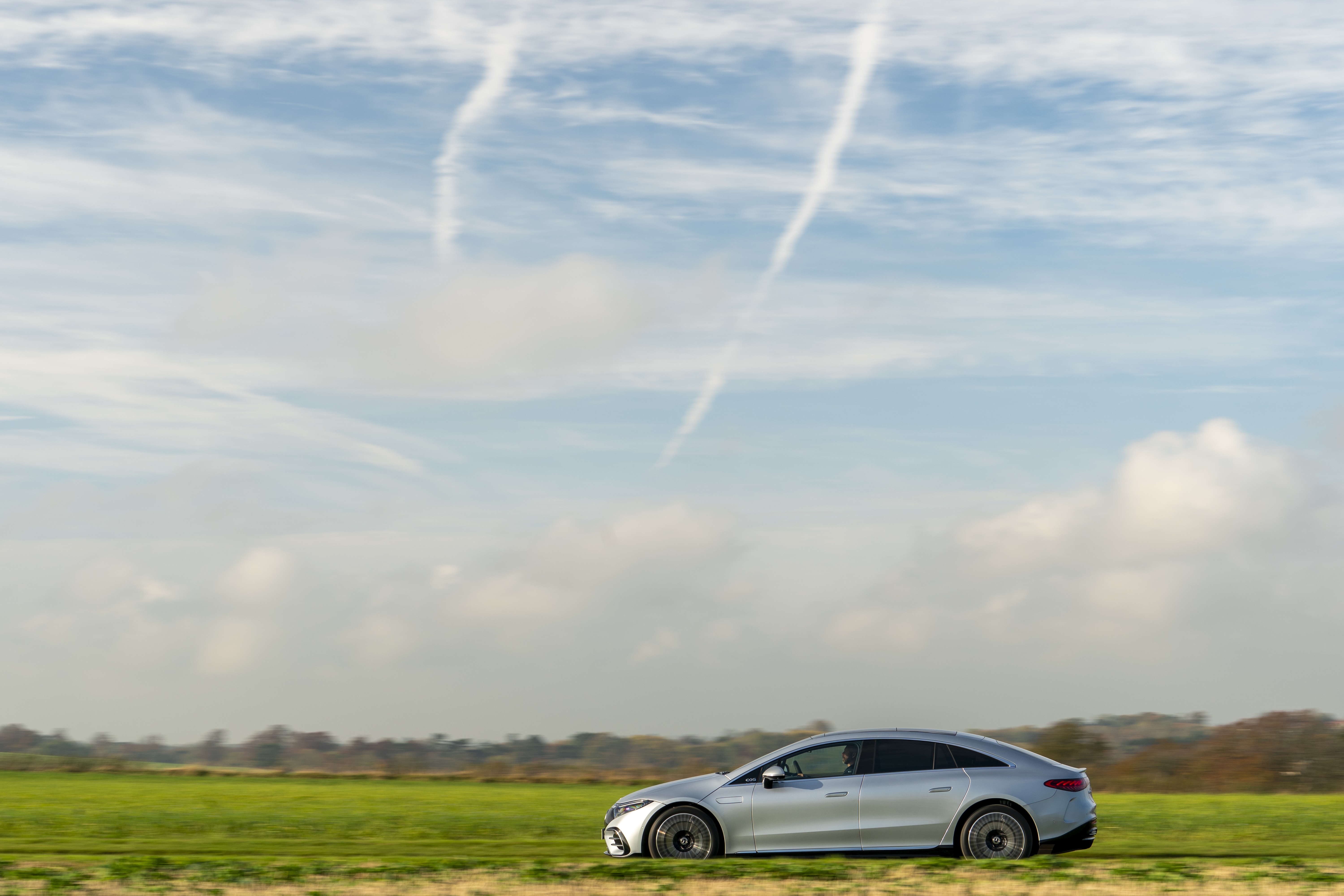 Mercedes-Benz EQS 450 AMG Line driving on a road HD Wallpaper