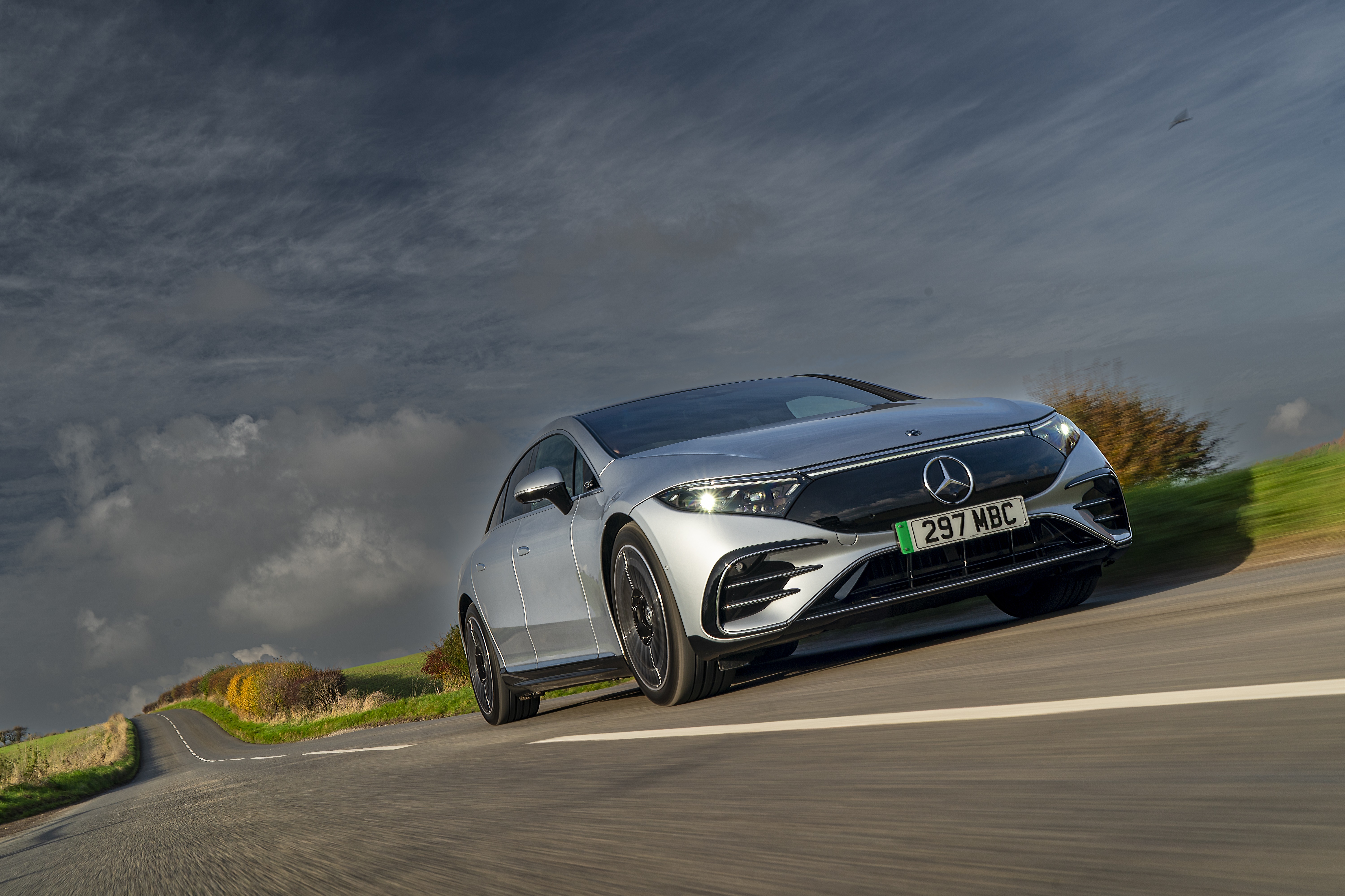 Silver Mercedes-Benz EQS 450 AMG Line driving on a road HD Wallpaper