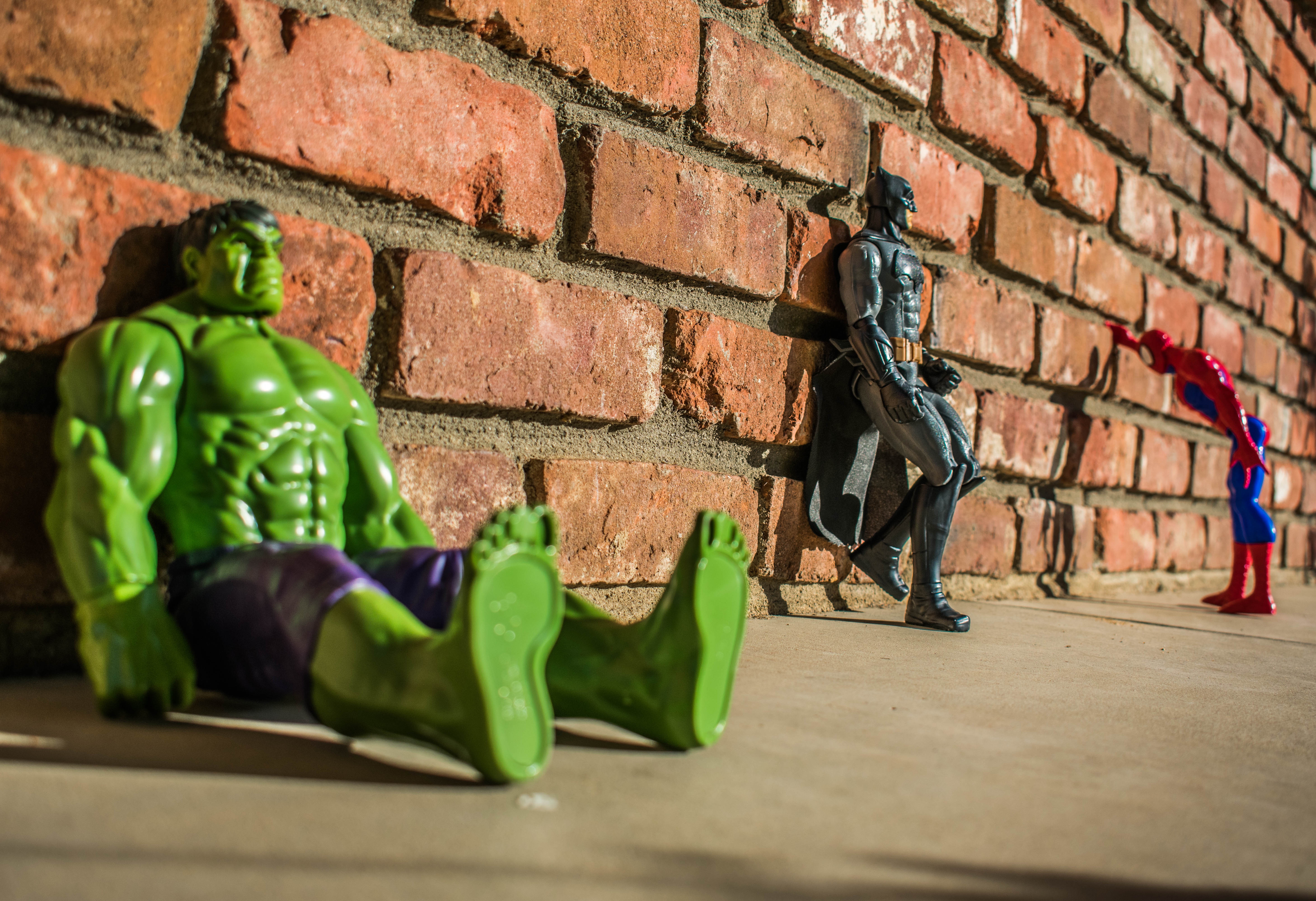 Hulk, Batman, and Spider-Man figures by a brick wall HD Wallpaper