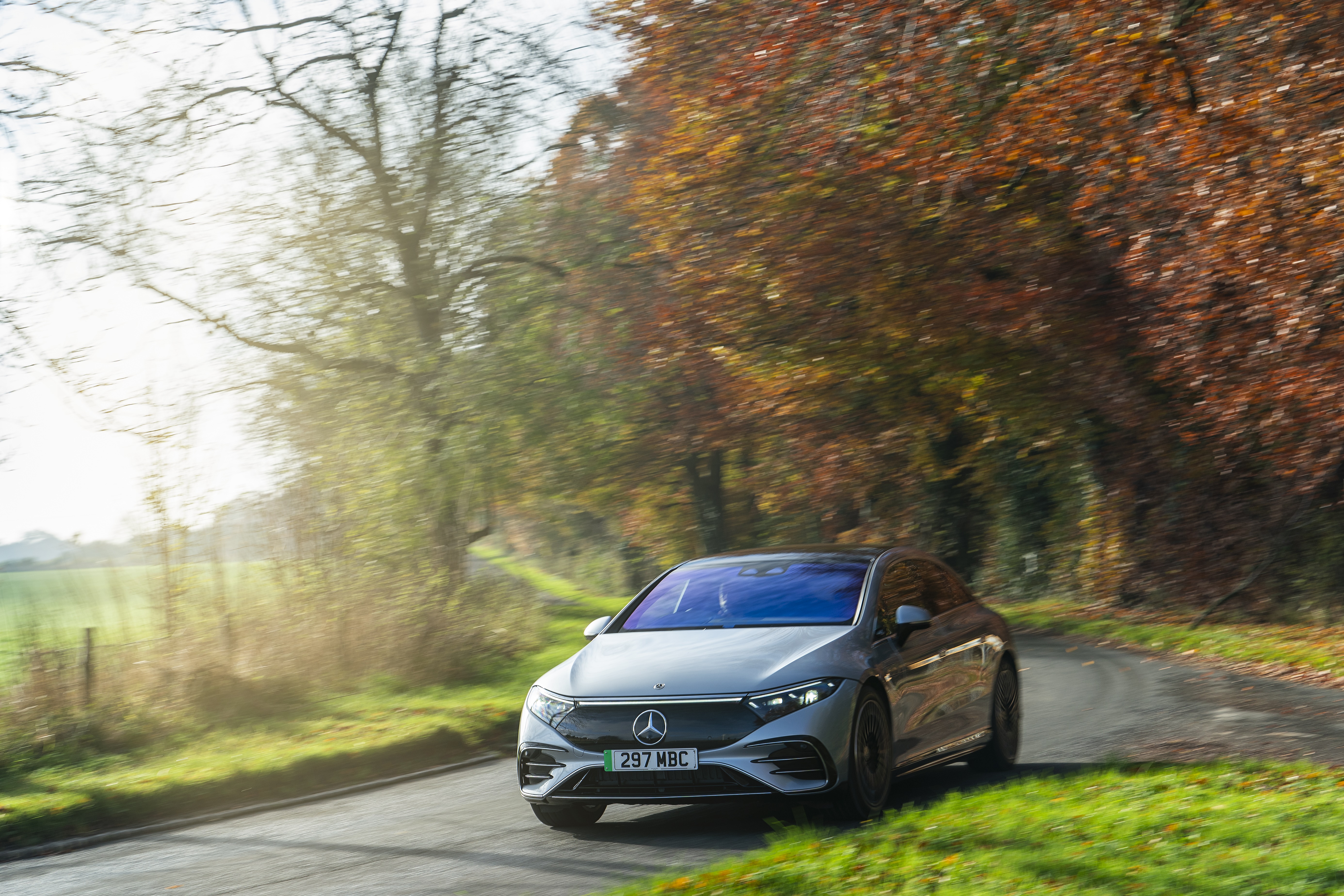 Mercedes-Benz EQS 450 AMG Line driving on a road HD Wallpaper
