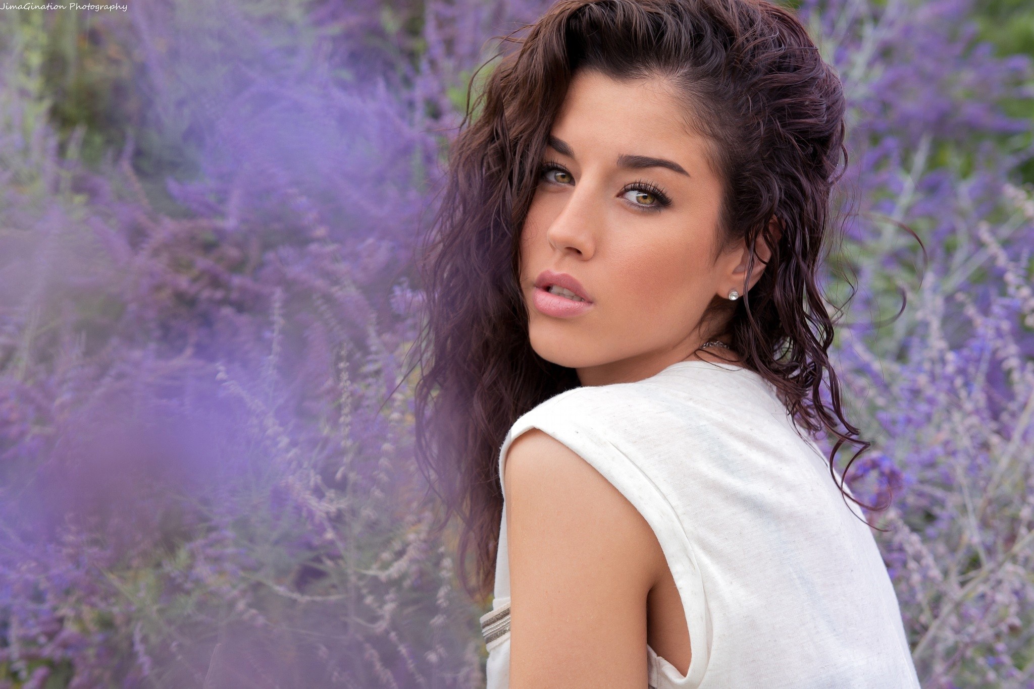 Brunette model posing in front of purple flowers HD Wallpaper