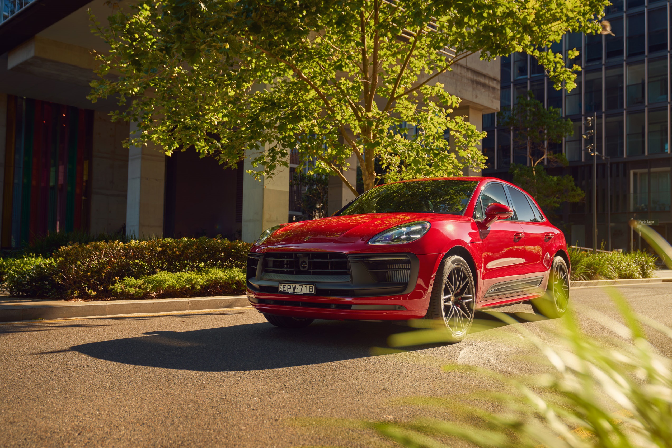 Red Porsche Macan GTS parked on a street HD Wallpaper