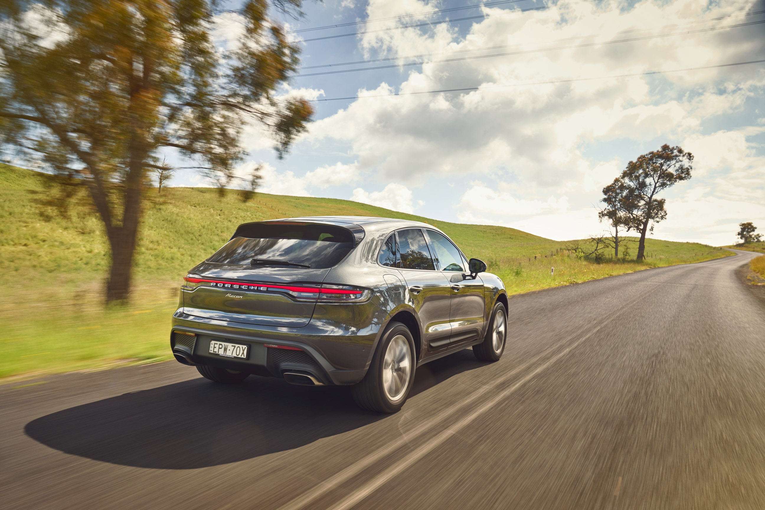 Porsche Macan driving on a country road HD Wallpaper