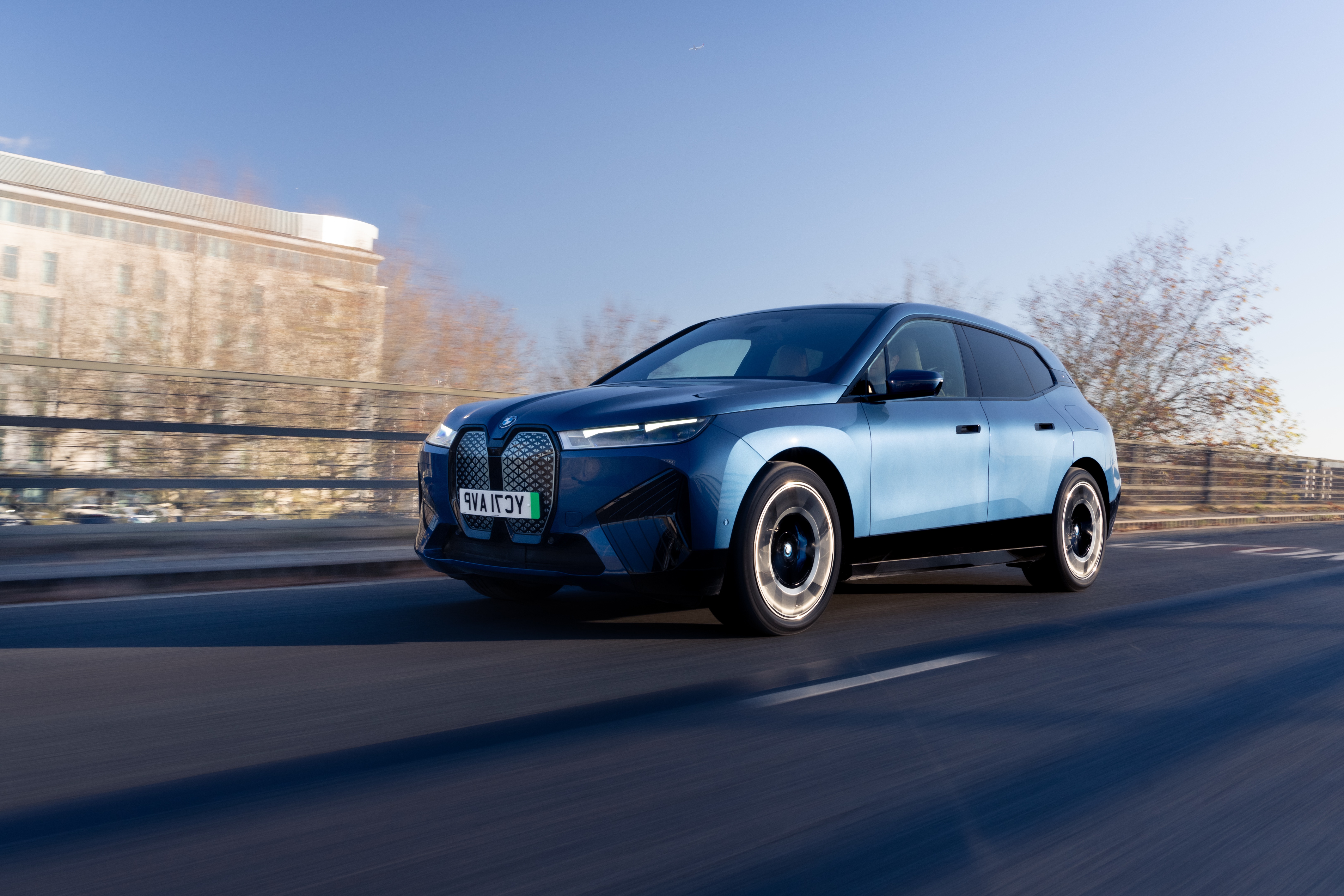 Blue BMW iX xDrive40 Sport SUV driving on road HD Wallpaper