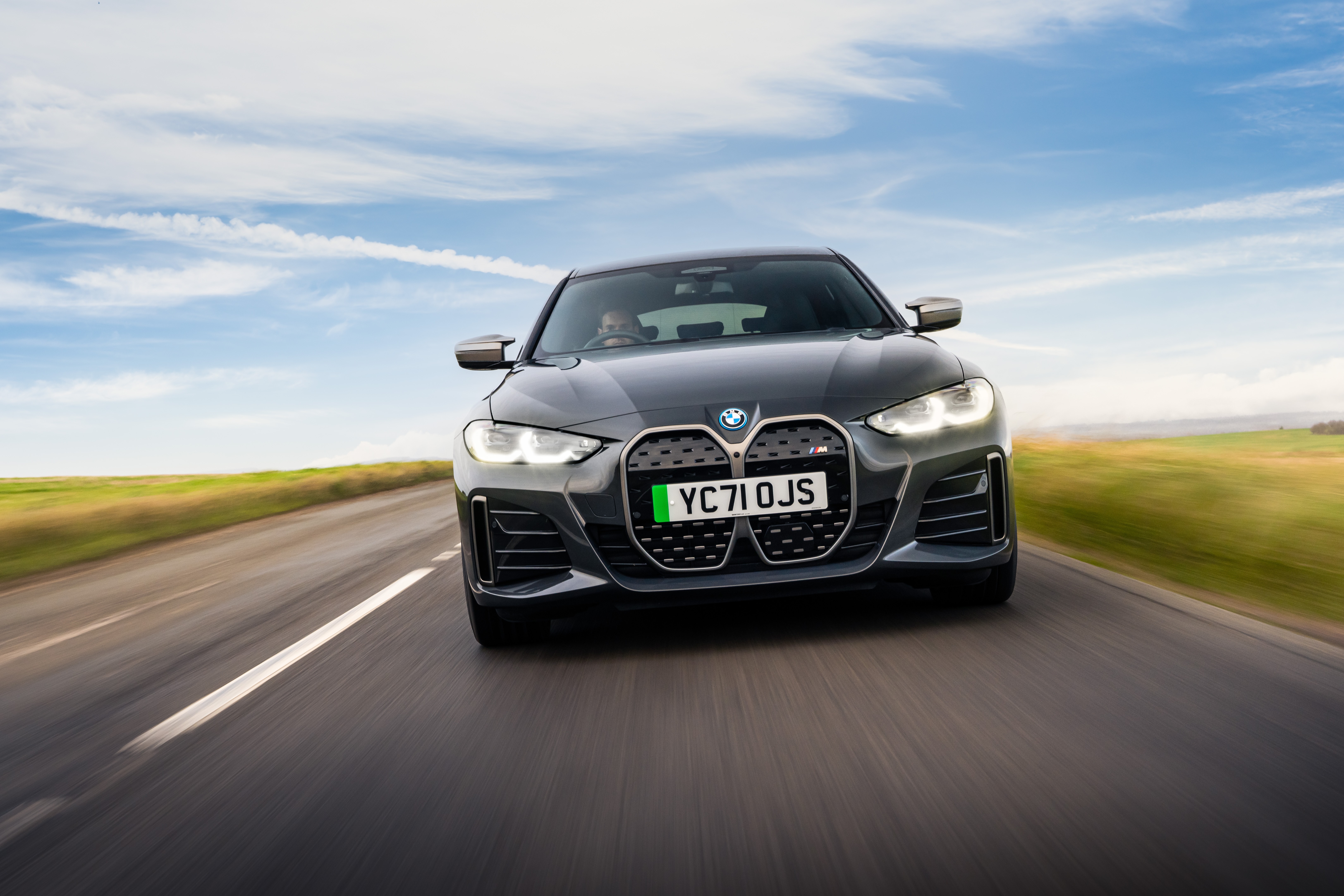 BMW i4 M50 driving on a road HD Wallpaper