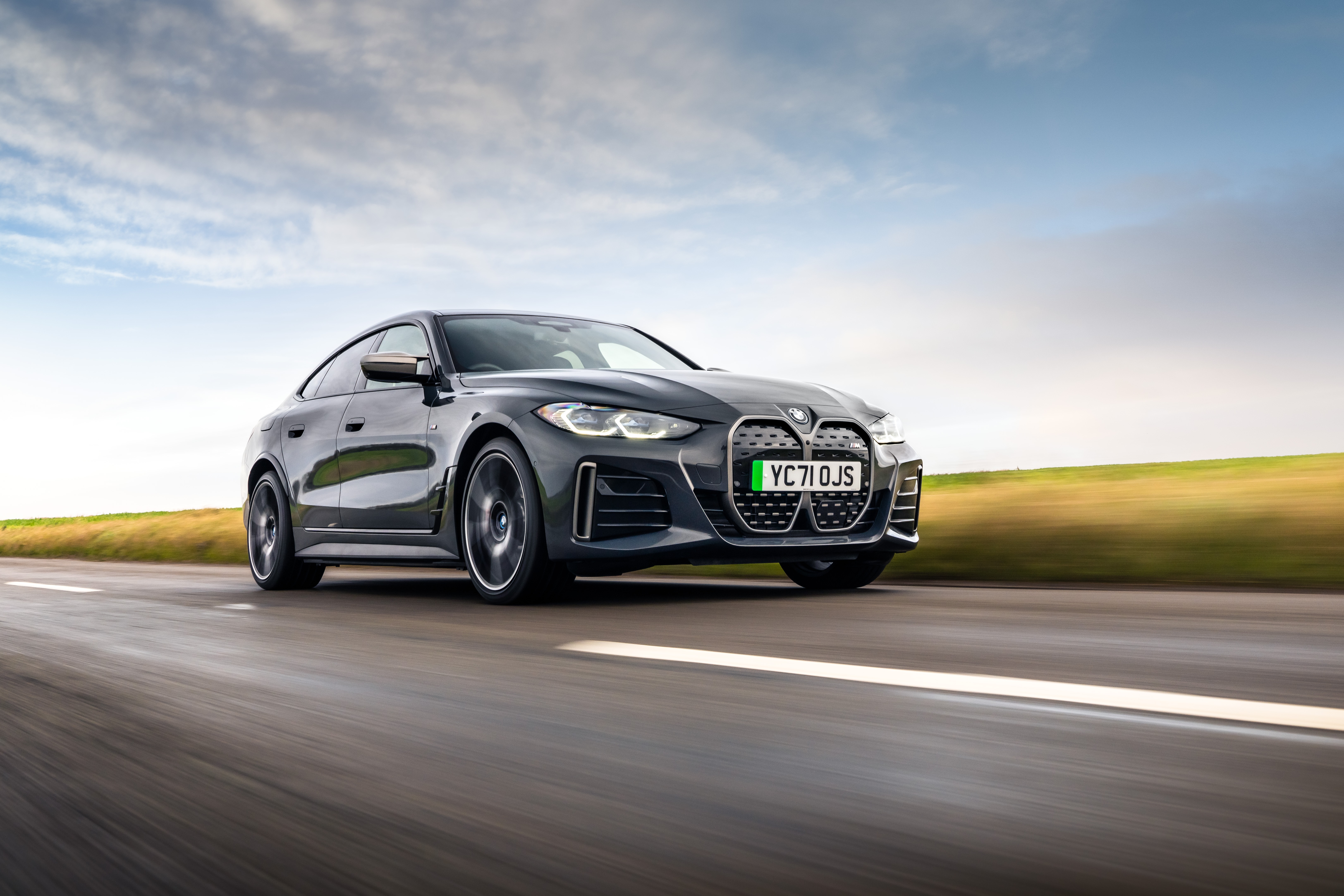 BMW I4 M50 driving on a road HD Wallpaper