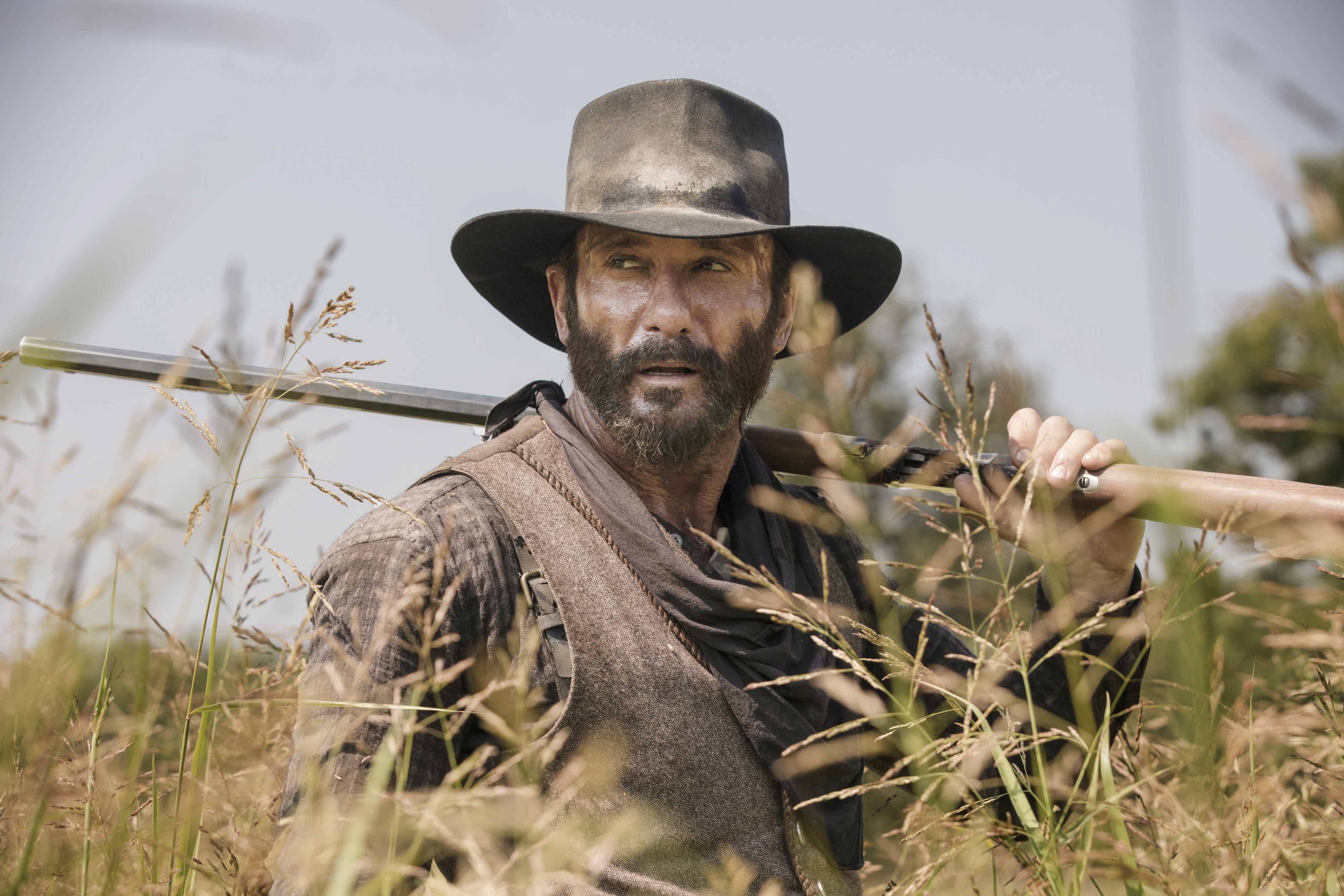 Man with rifle in tall grass HD Wallpaper