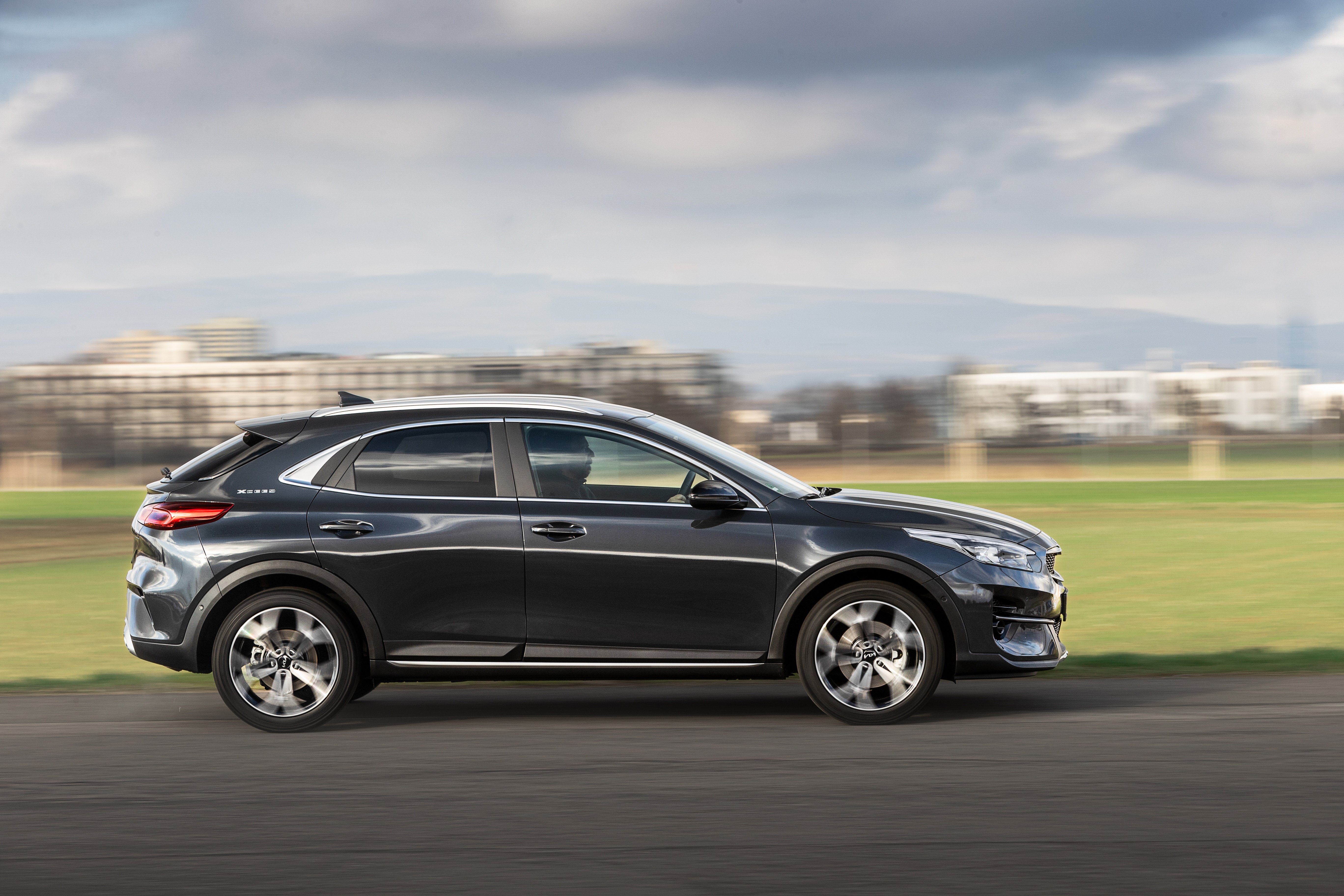 Dark gray Kia XCeed driving on a road HD Wallpaper