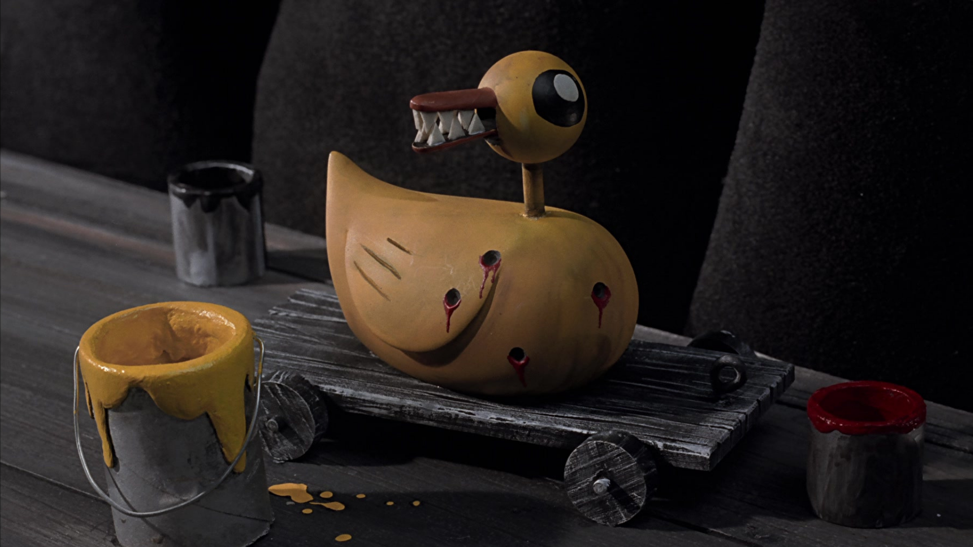 A creepy yellow duck toy with sharp teeth and bullet holes HD Wallpaper