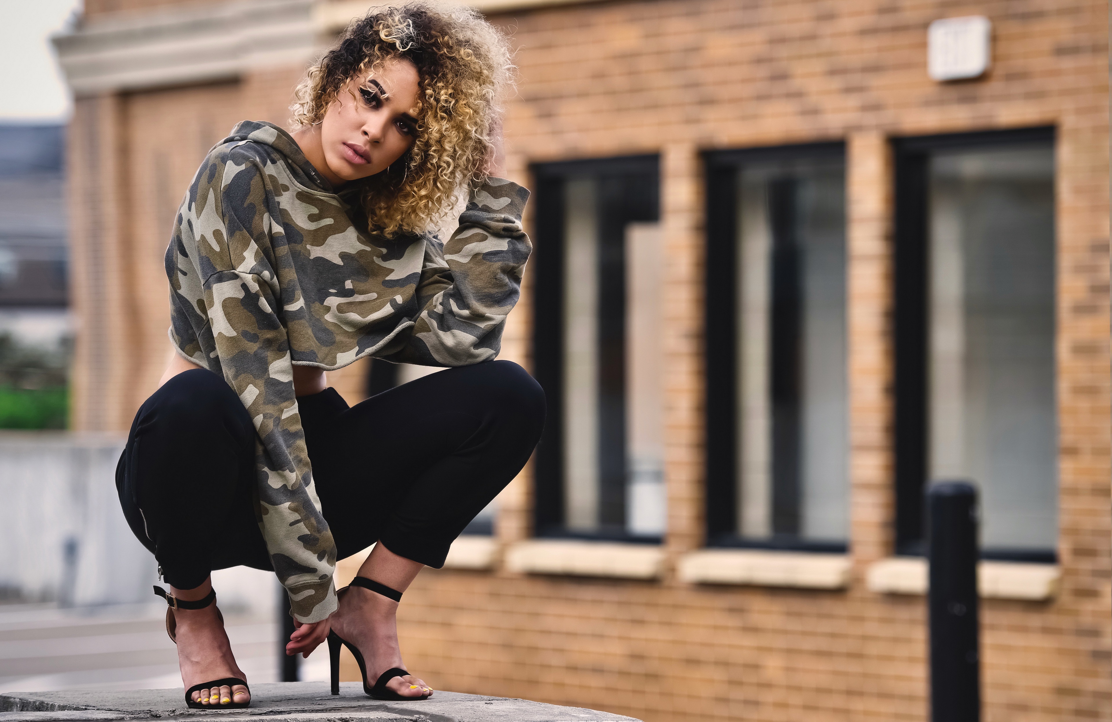 Model in camouflage hoodie and black pants HD Wallpaper