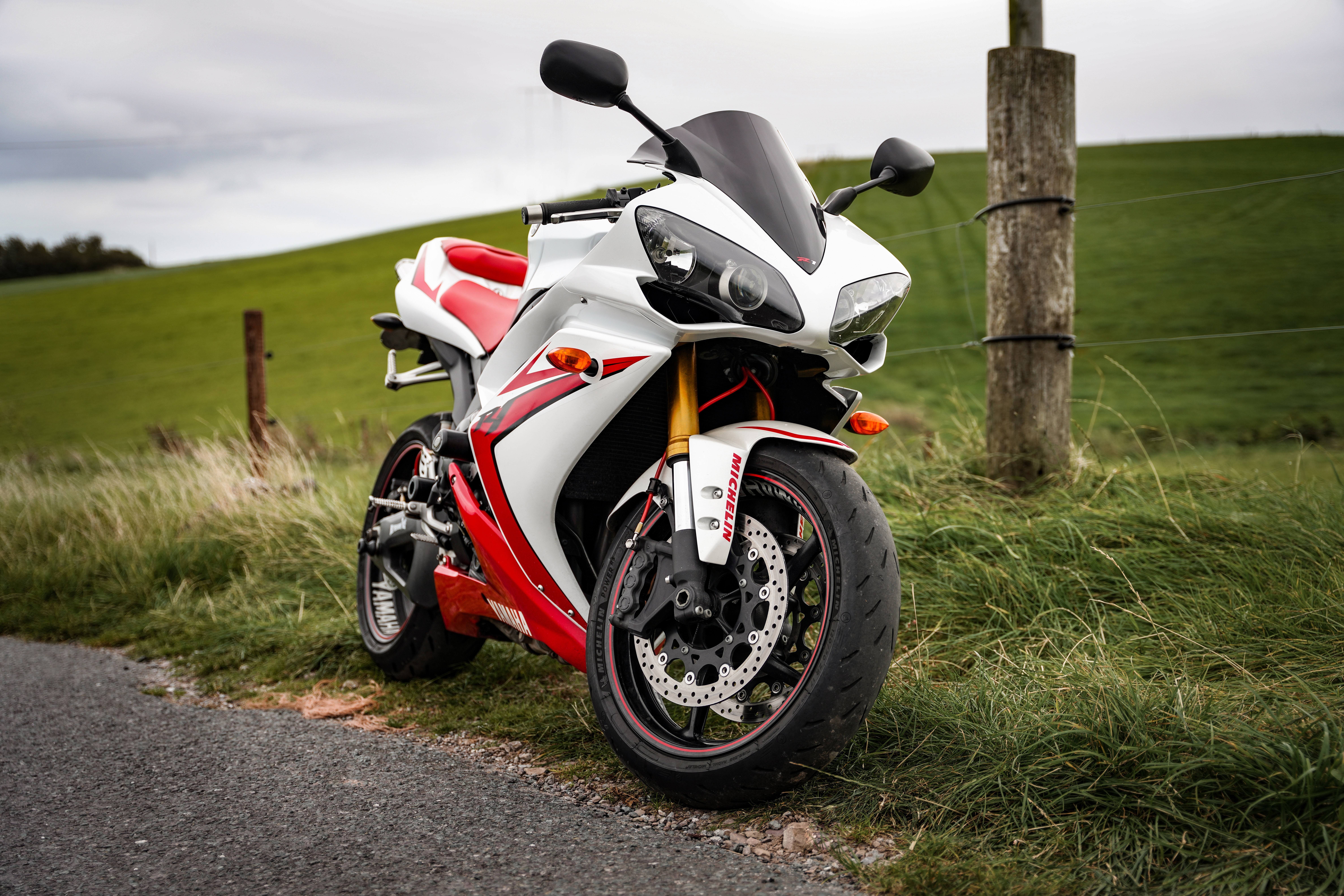 White and red Yamaha YZF-R1 motorcycle on a grassy field HD Wallpaper