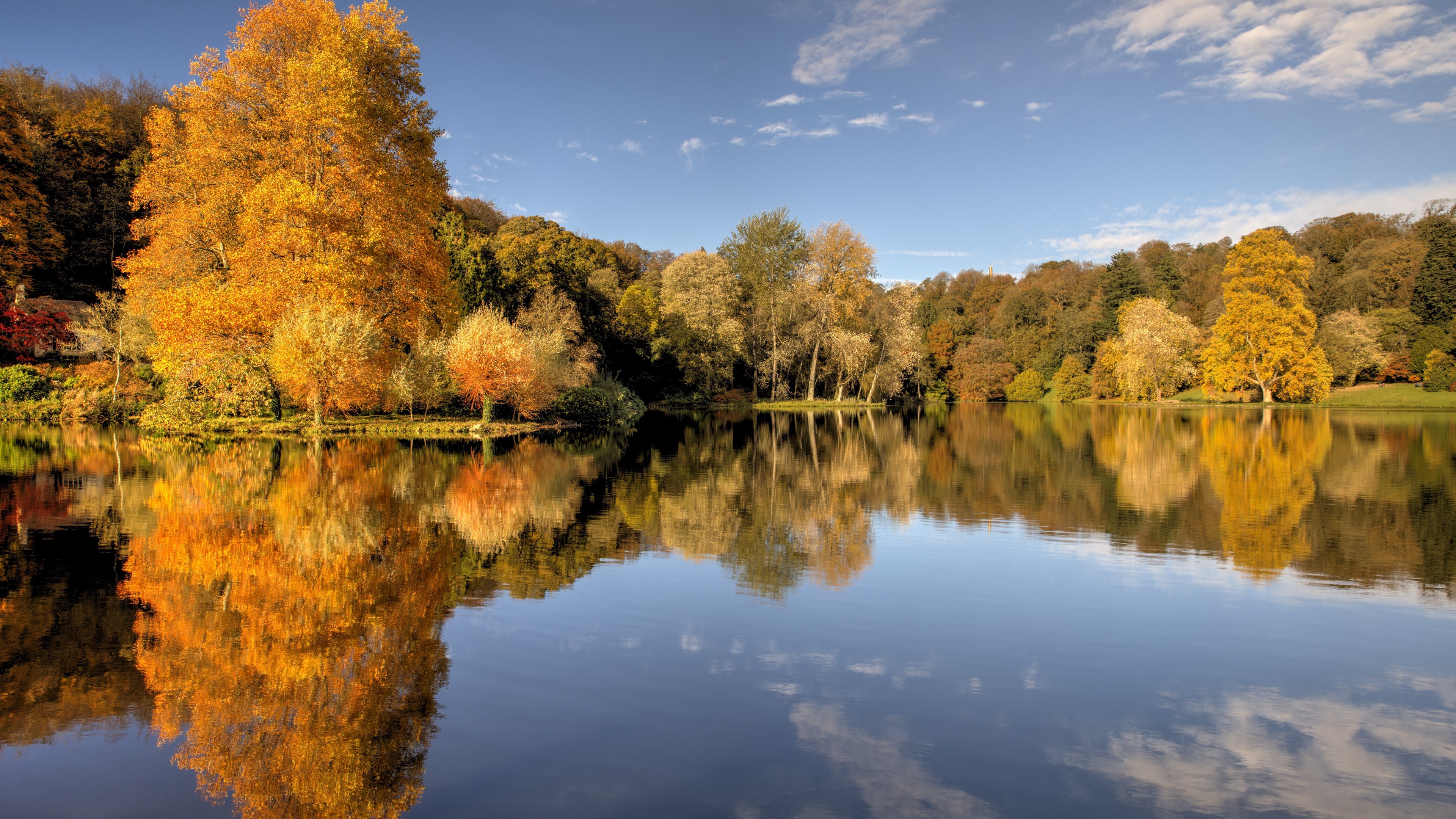 Autumn trees reflecting in a lake HD Wallpaper