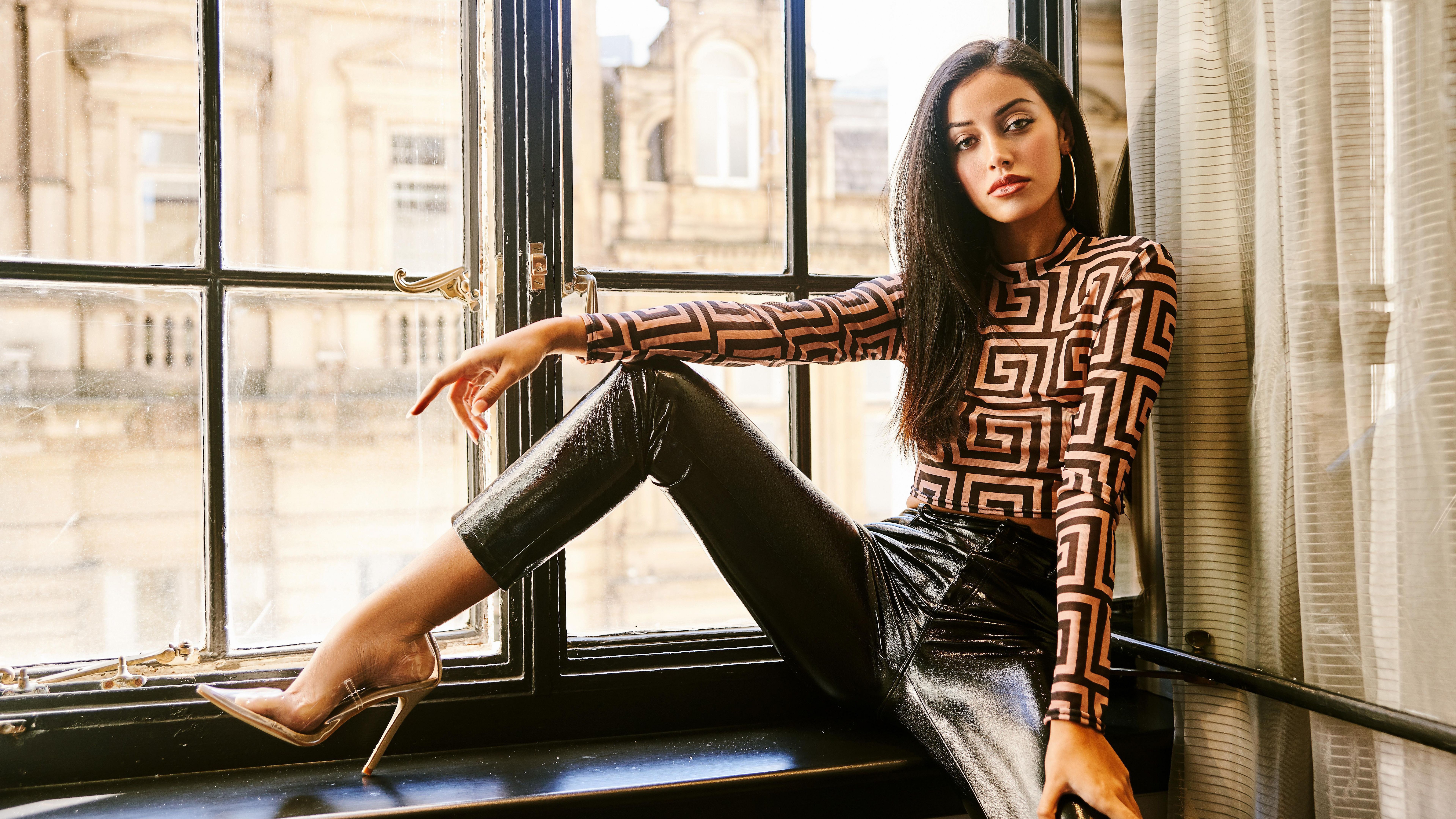 Woman with black hair wearing patterned top and leather pants HD Wallpaper