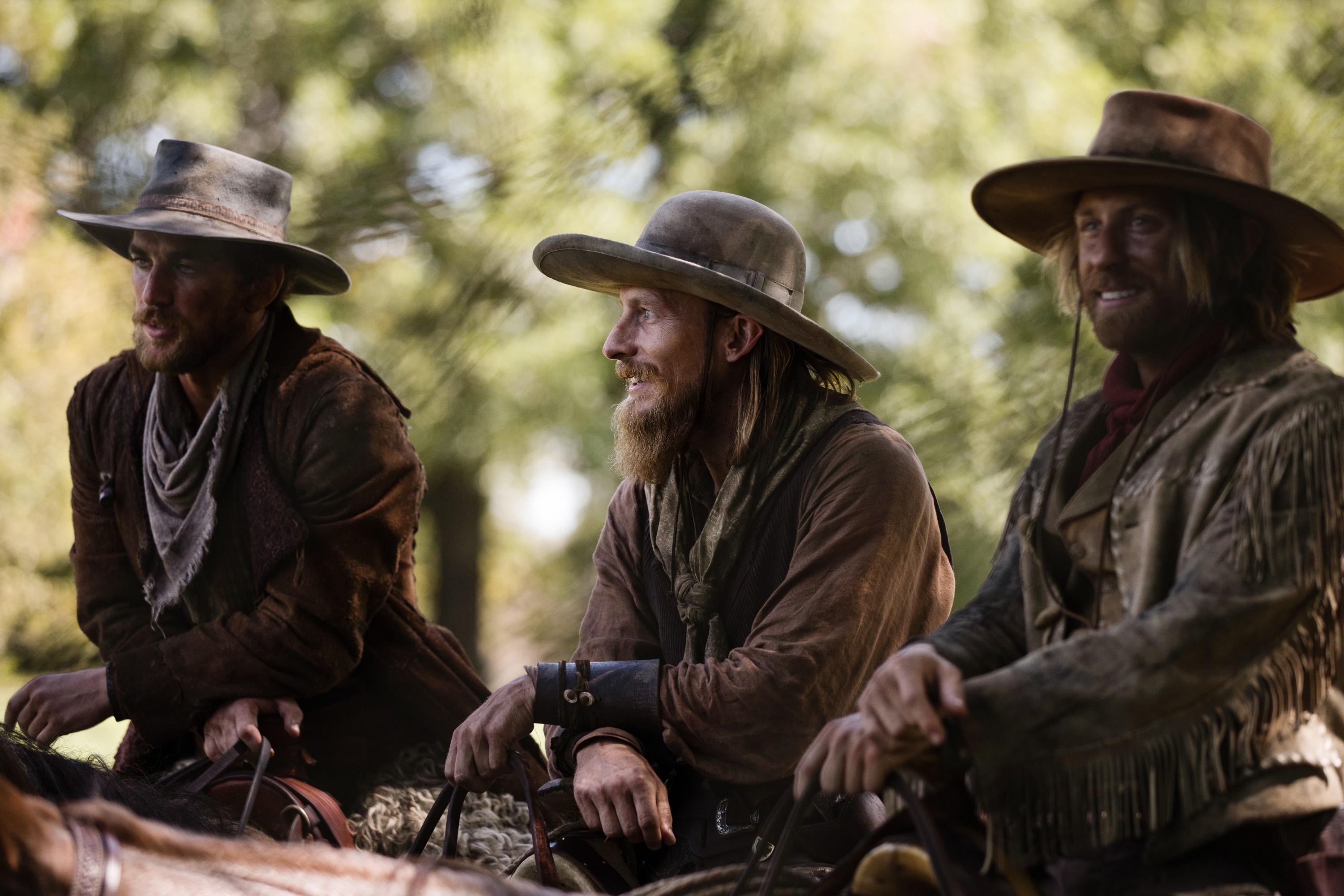 Three cowboys on horseback in a forest HD Wallpaper