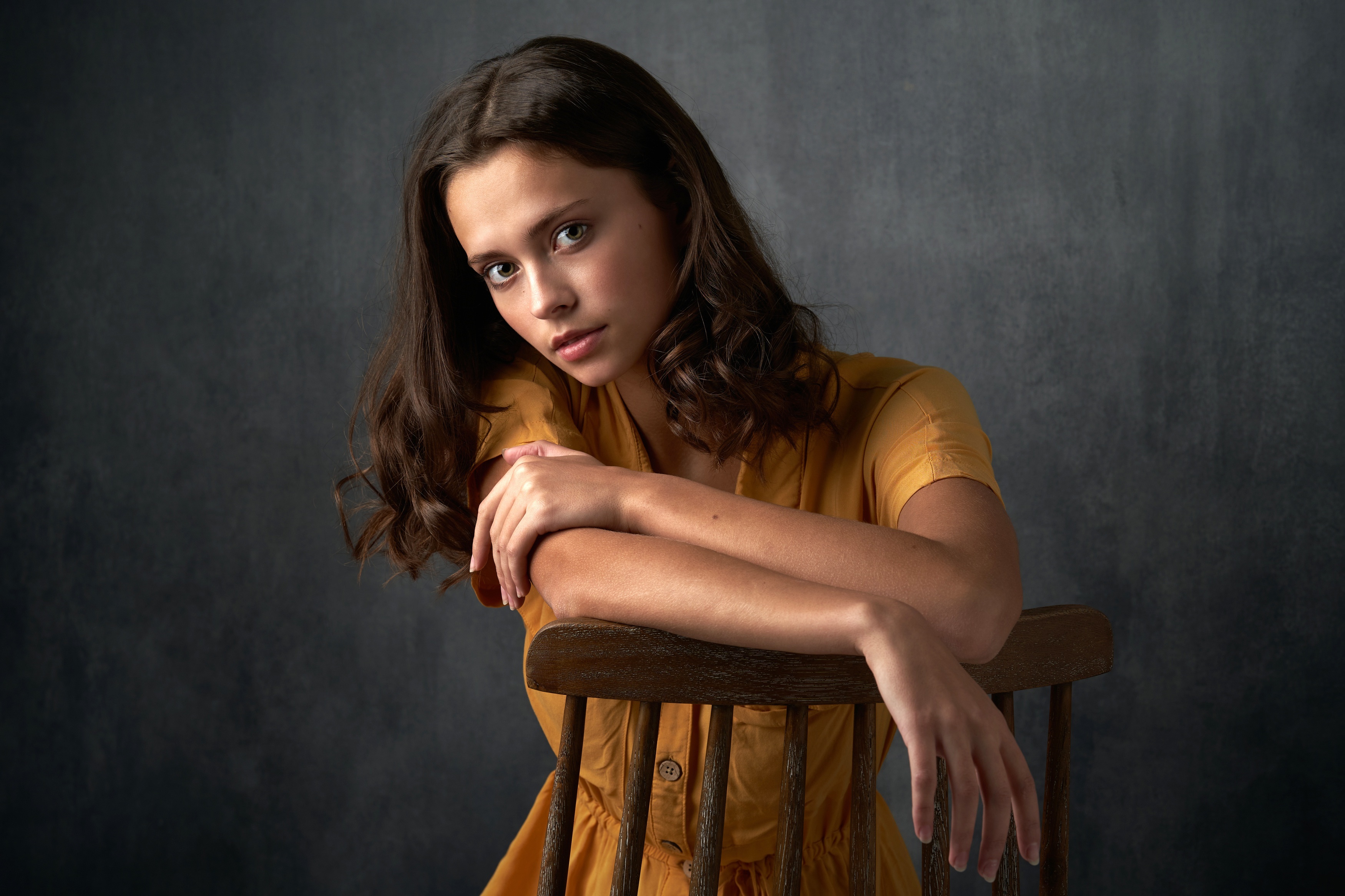 Brunette woman sitting on a chair HD Wallpaper
