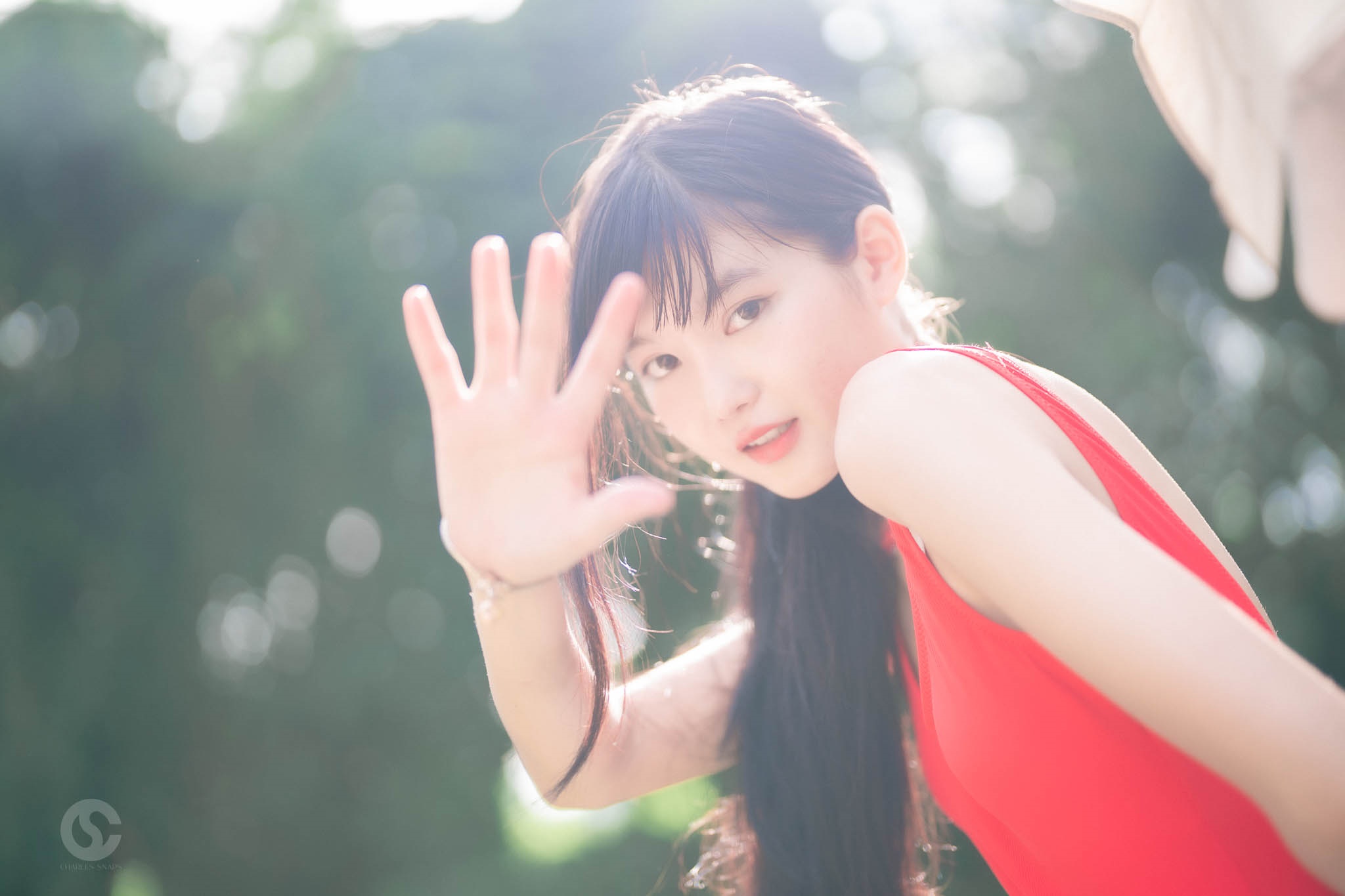 Young Asian woman in red dress with hand raised HD Wallpaper