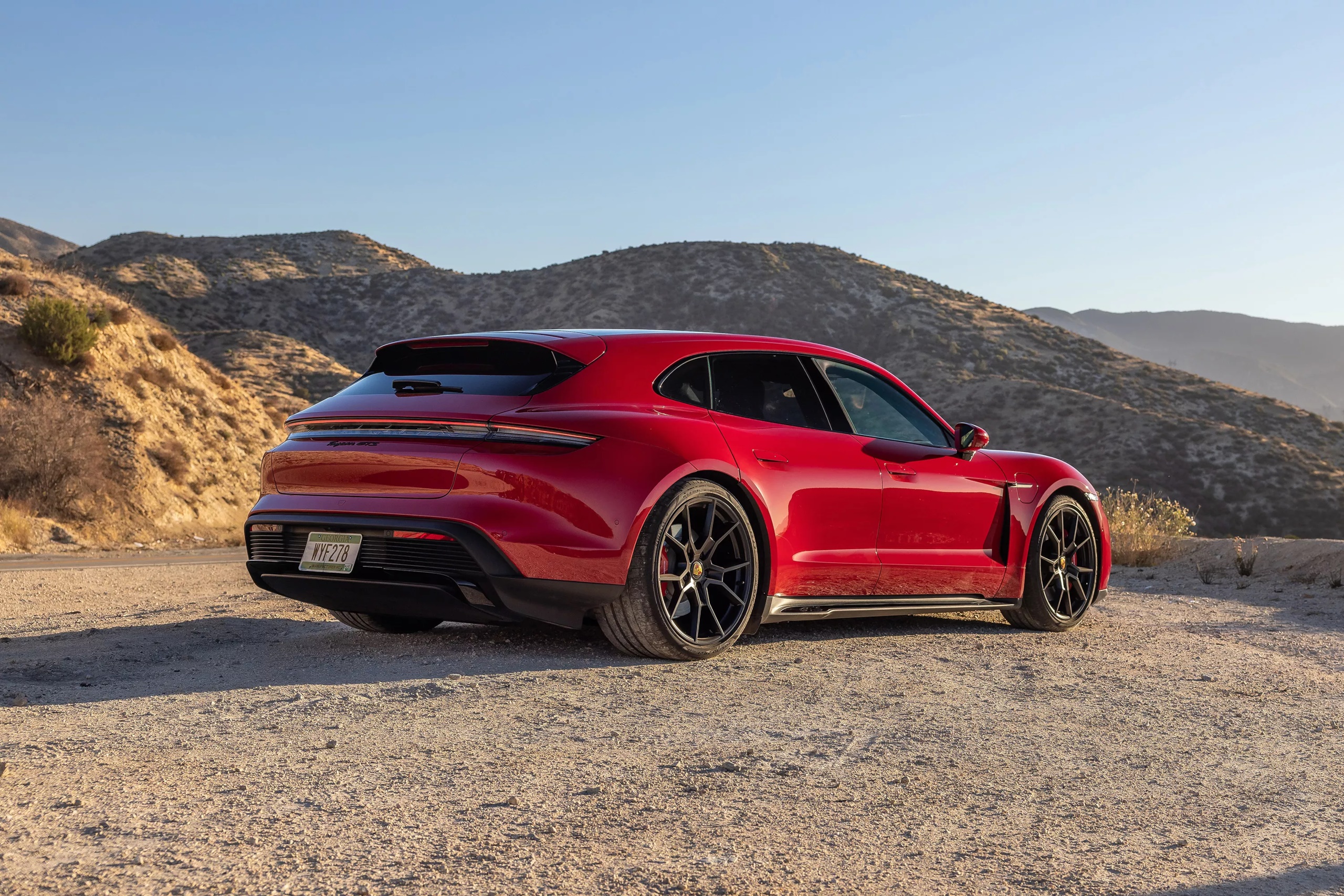 Red 2022 Porsche Taycan GTS Sport Turismo on dirt road HD Wallpaper