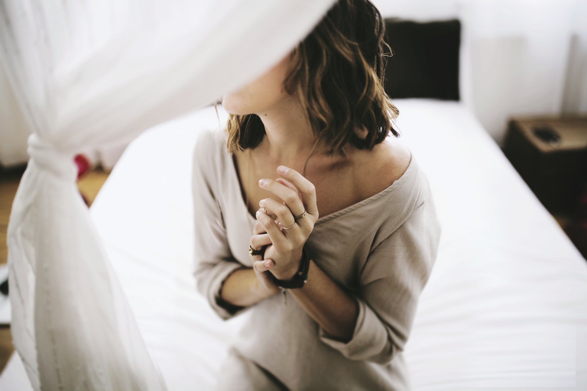 Woman sitting on a bed in an Airbnb HD Wallpaper