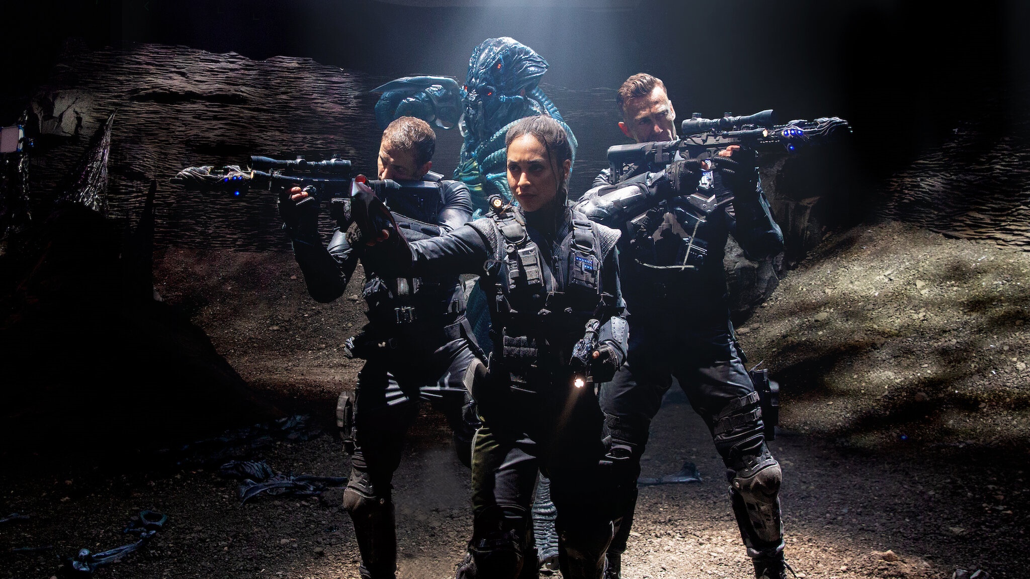 Three soldiers and an alien in a dark cave HD Wallpaper