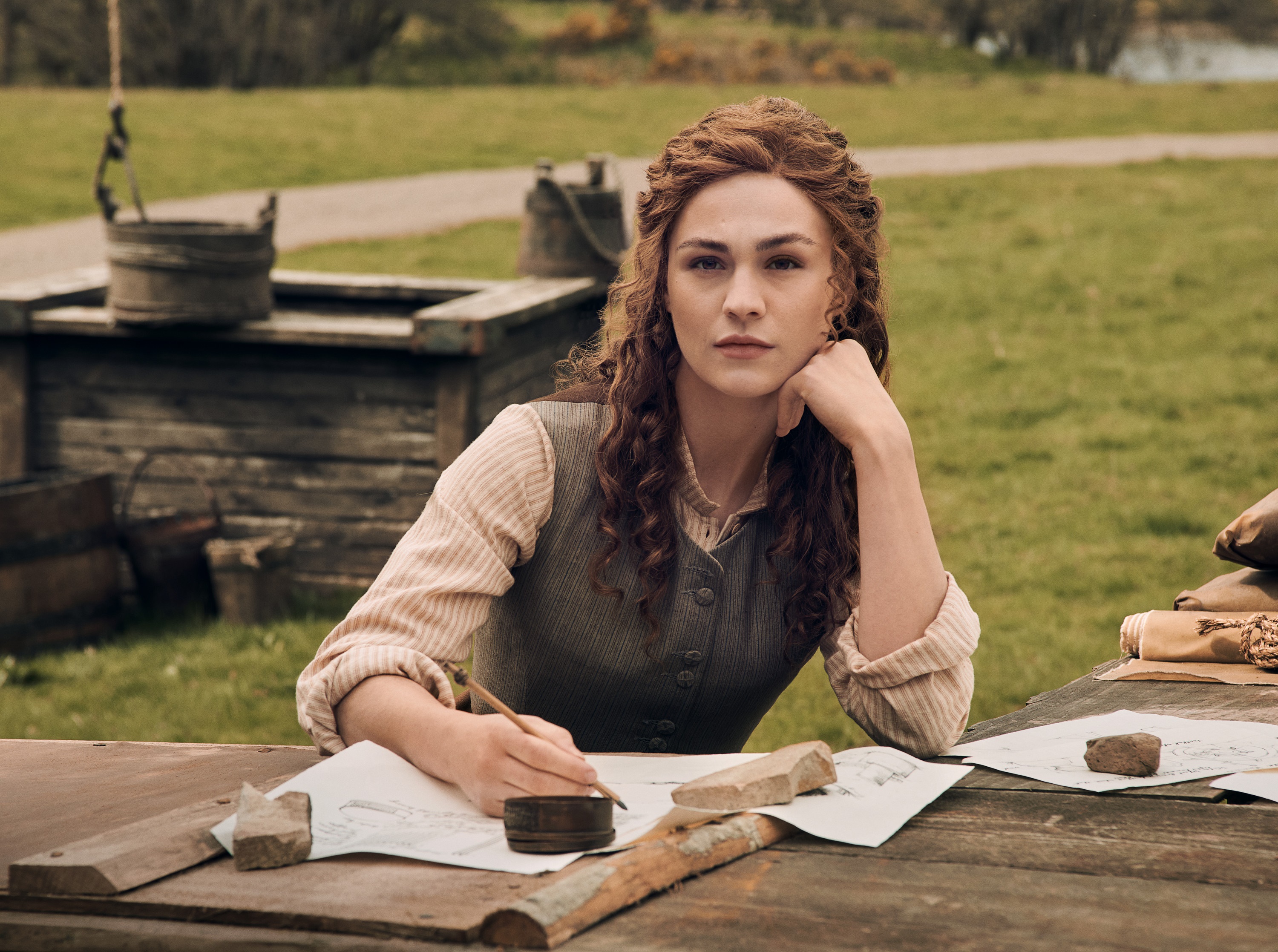 Woman from Outlander drawing at a table HD Wallpaper