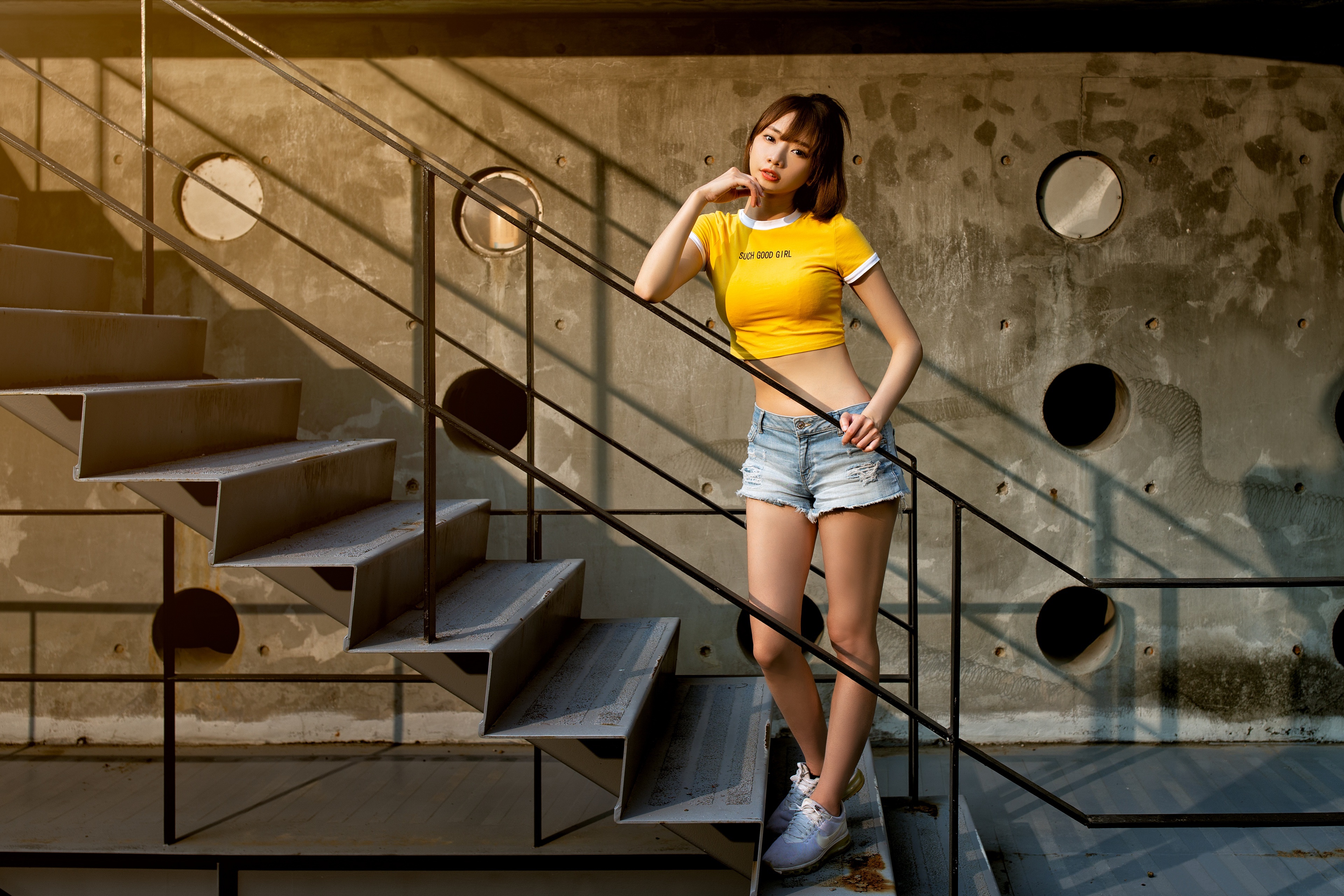 Asian woman in yellow crop top and denim shorts on stairs HD Wallpaper