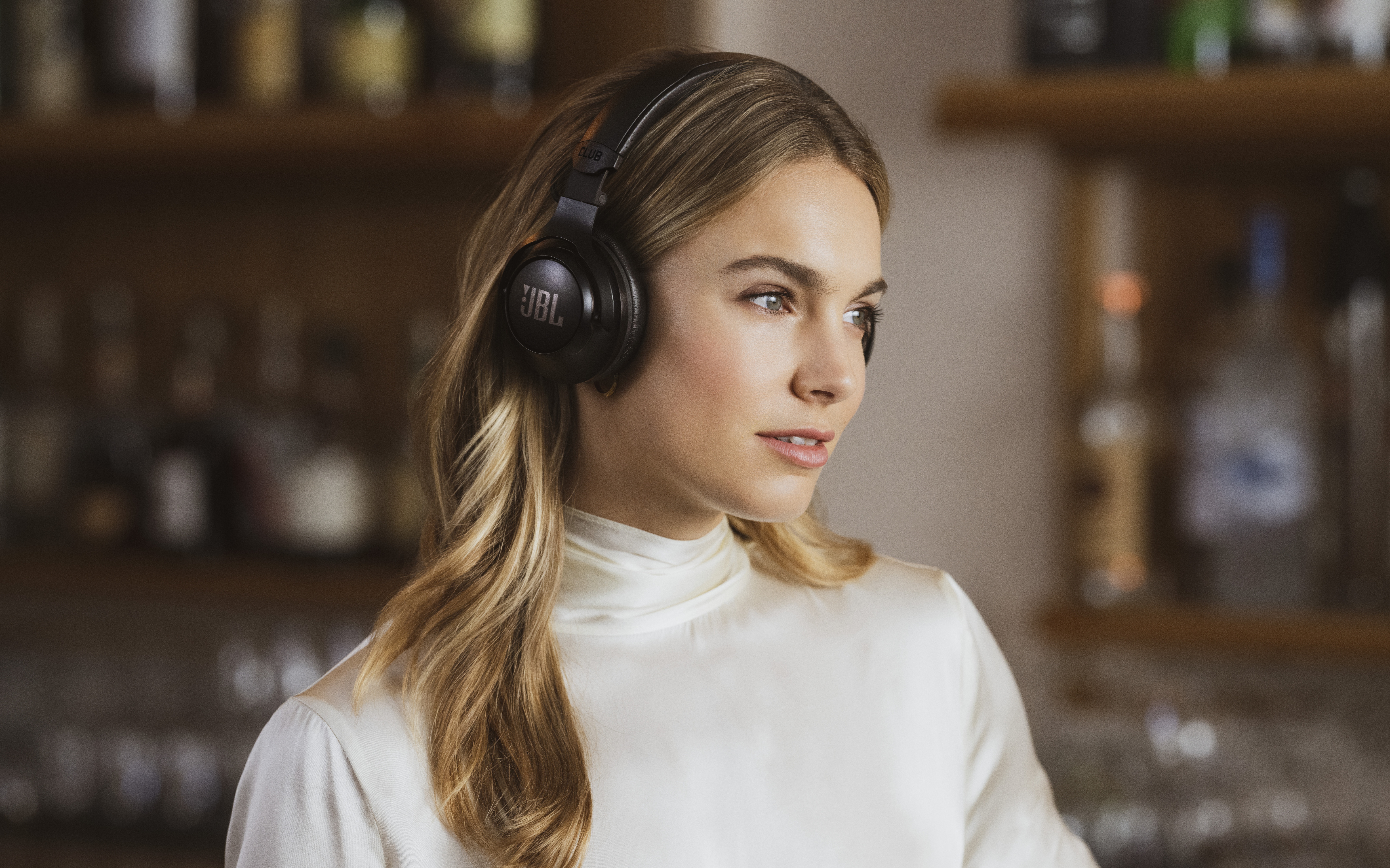 Woman wearing JBL headphones in a bar HD Wallpaper