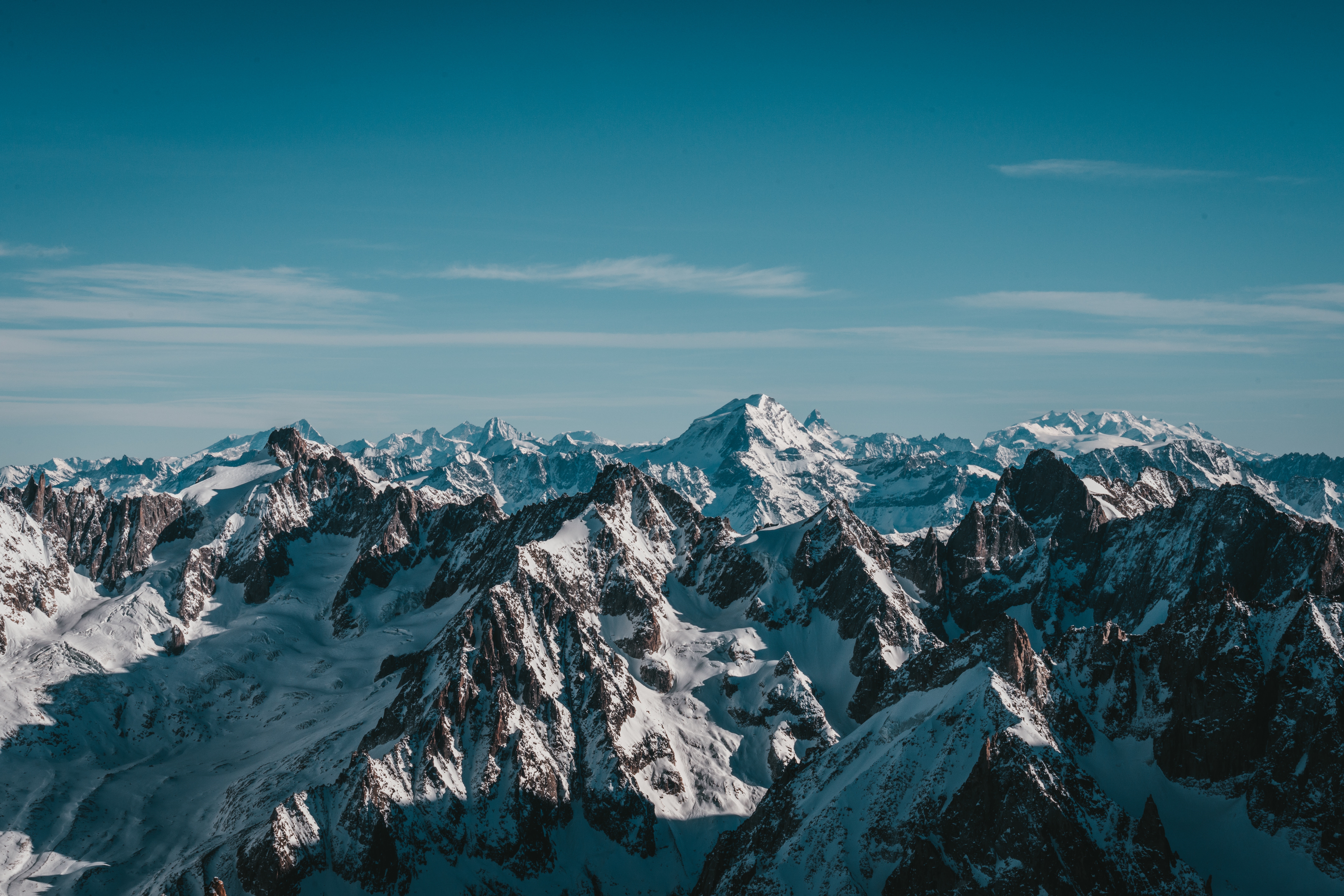 Snow-covered mountains under a clear blue sky HD Wallpaper