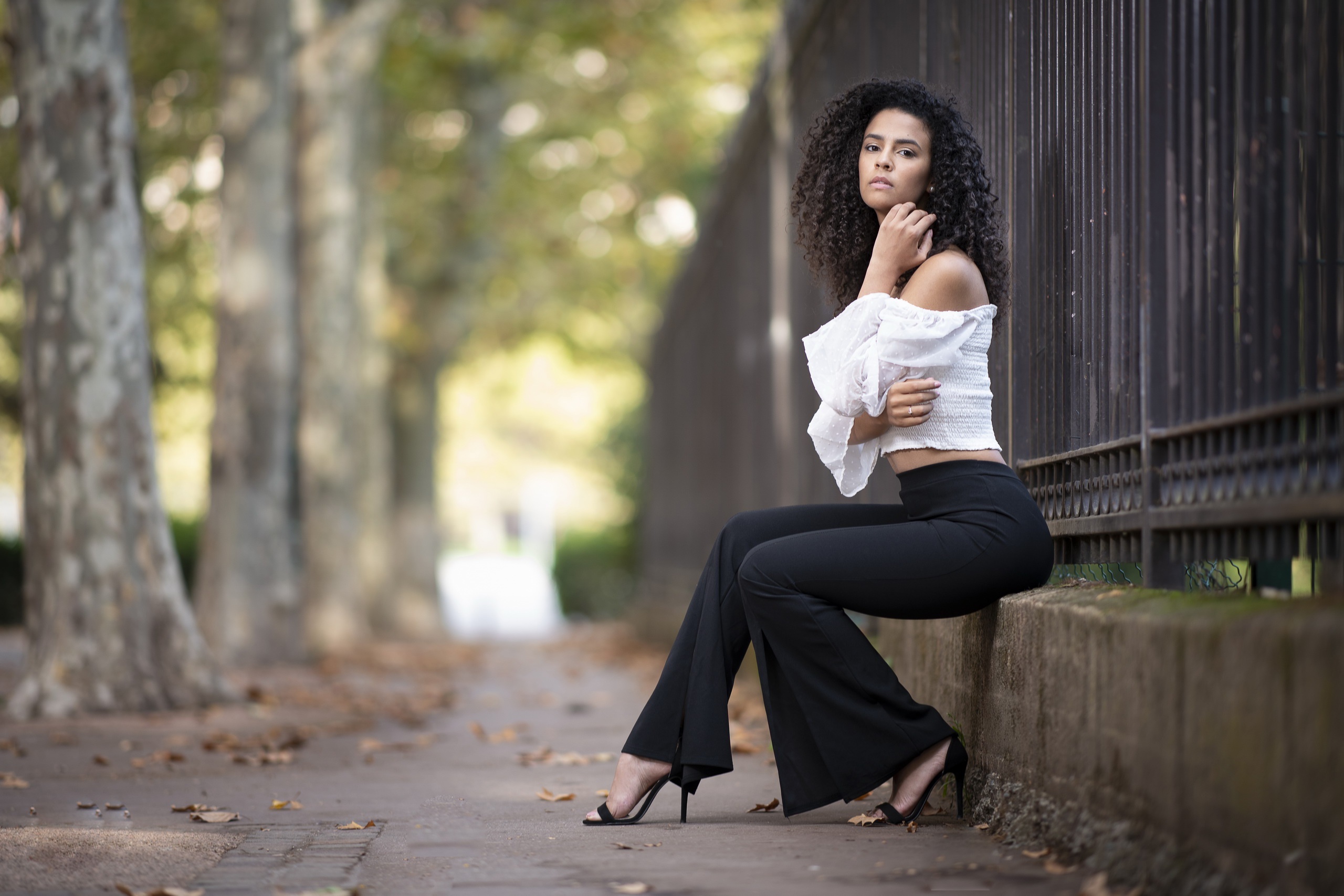 Woman with curly black hair in outdoor portrait HD Wallpaper