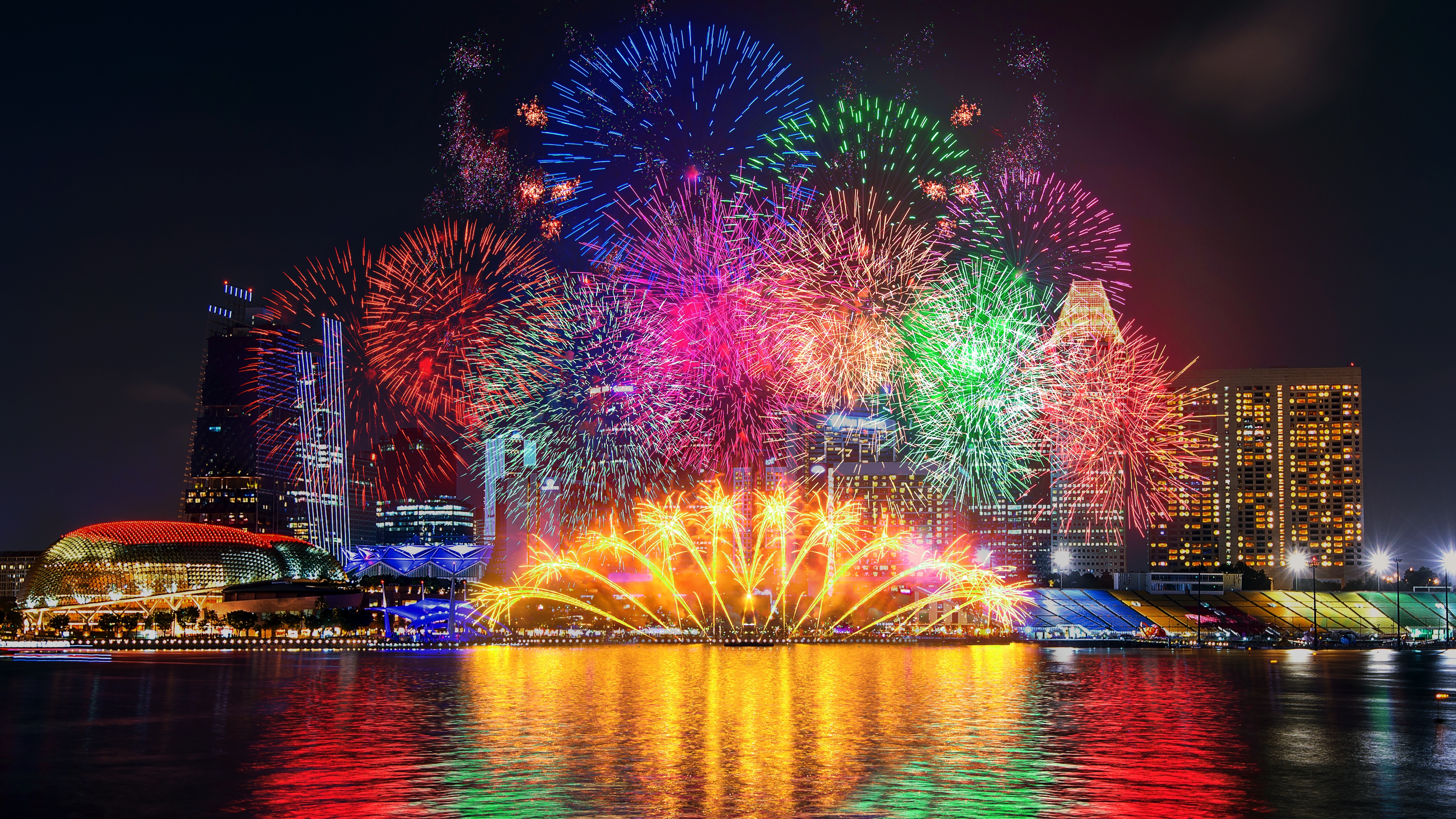 Fireworks over city skyline at night HD Wallpaper