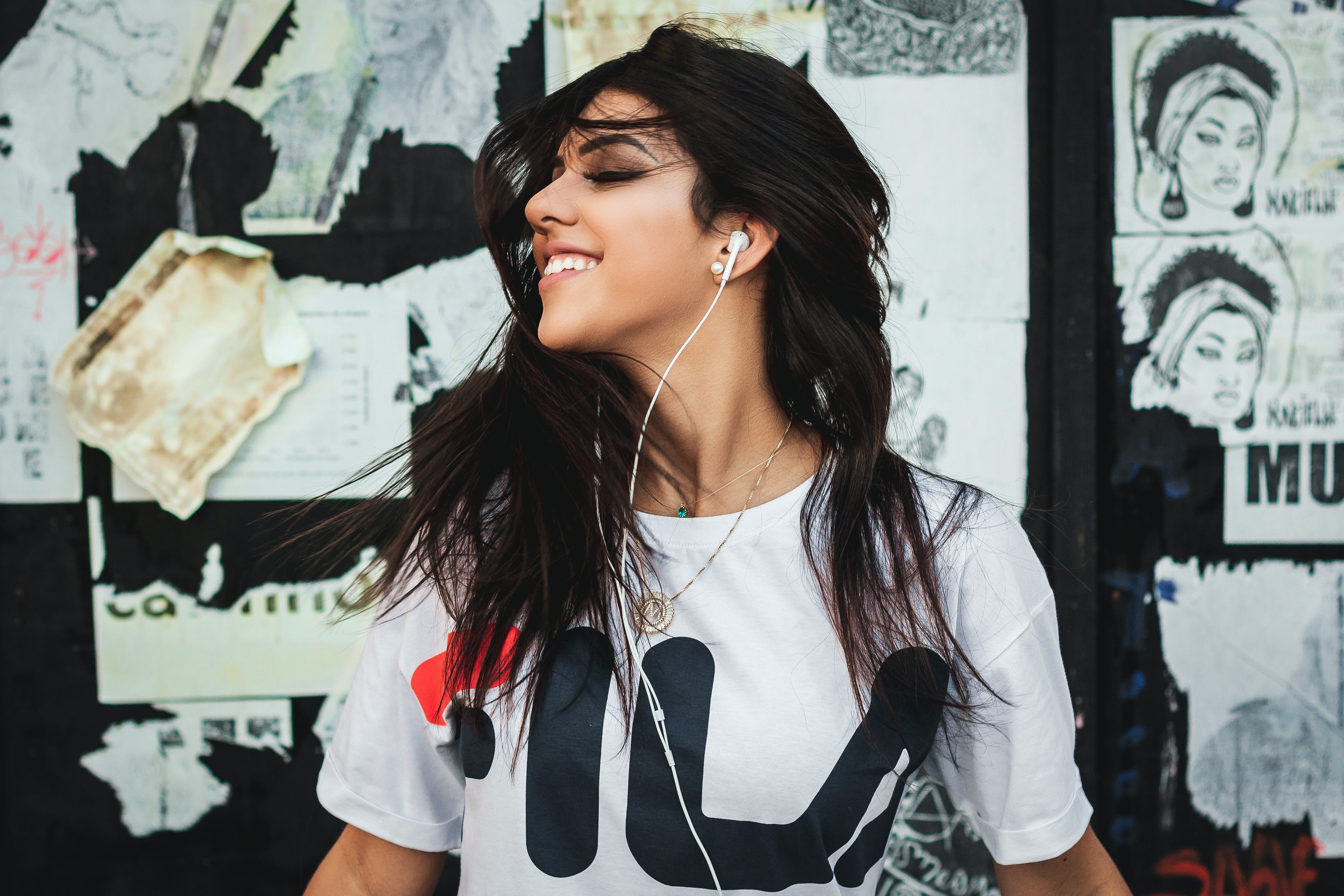 Woman with black hair wearing Fila t-shirt listening to music HD Wallpaper