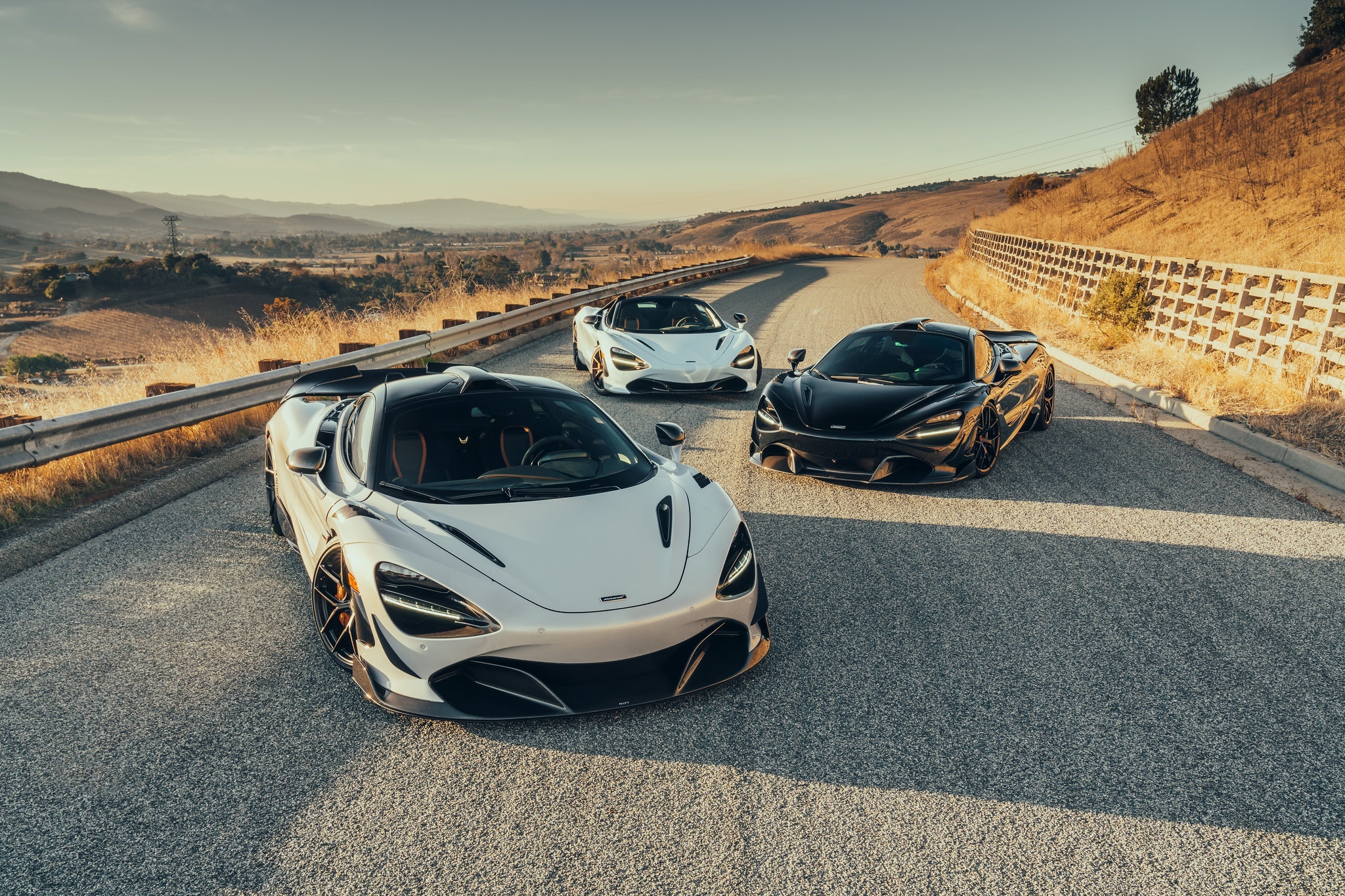Three McLaren supercars on a winding road HD Wallpaper