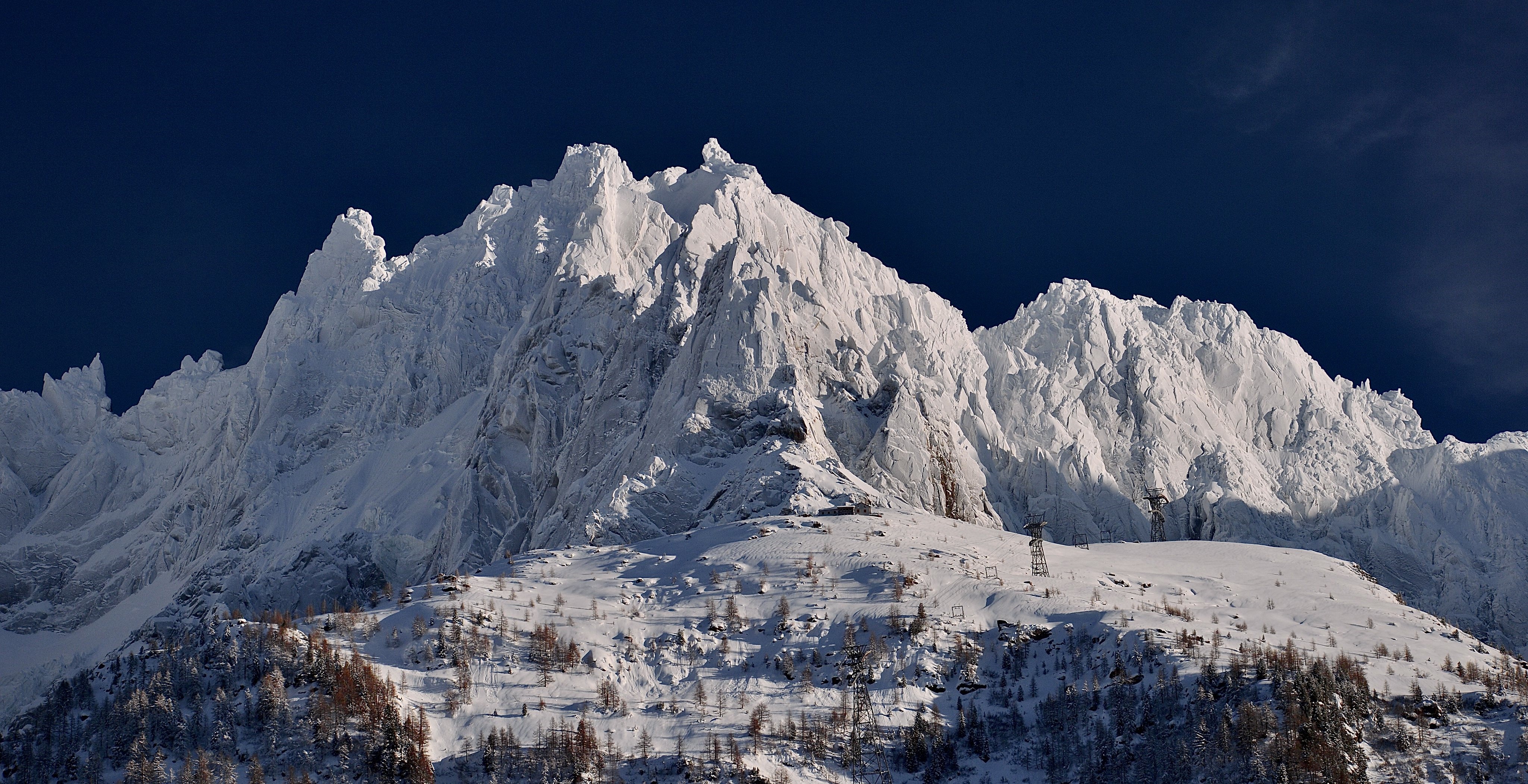 Snow-covered Aiguilles de Chamonix mountains under a dark blue sky HD Wallpaper