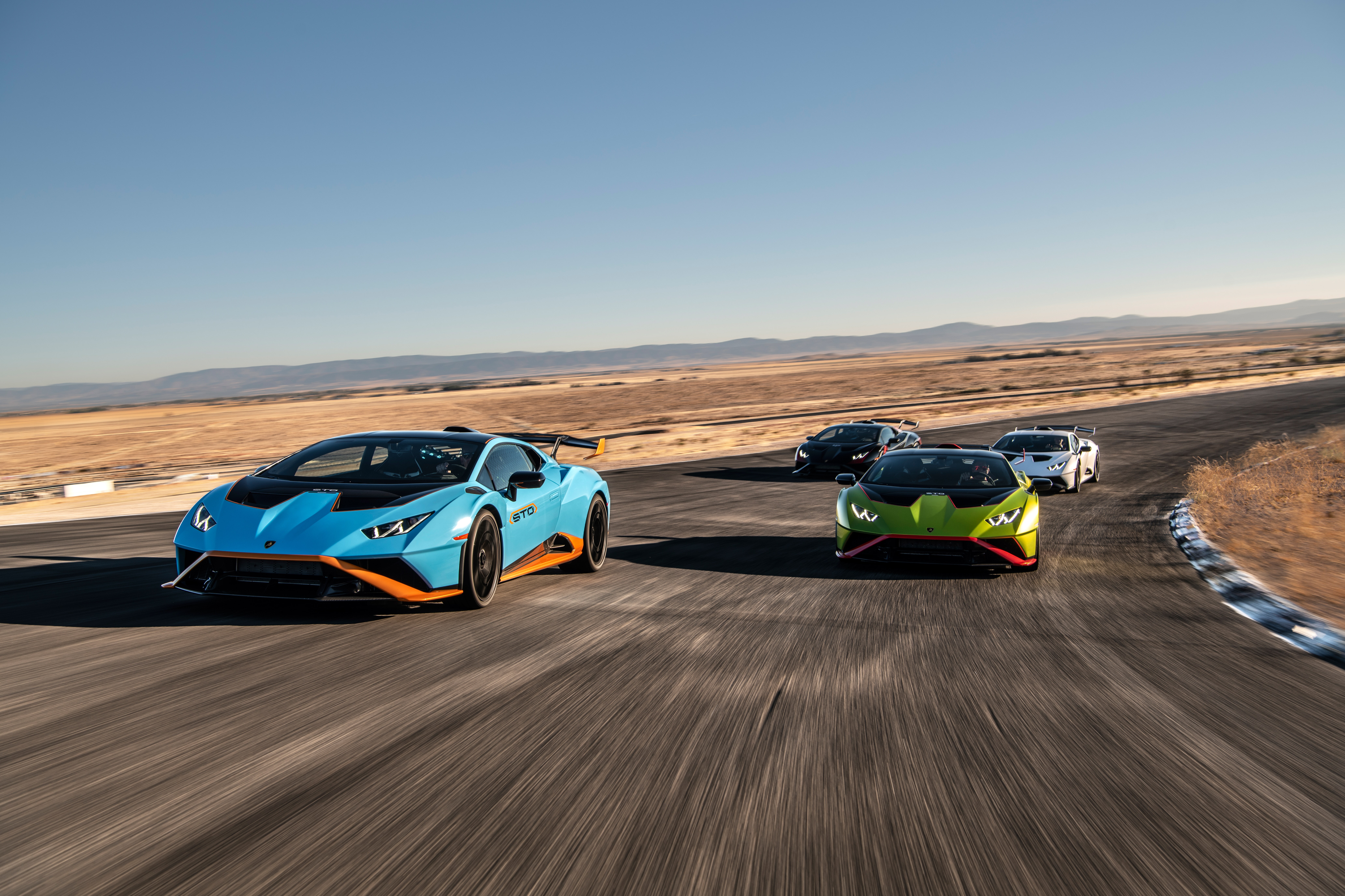 Lamborghini Huracán STO cars on a racetrack HD Wallpaper