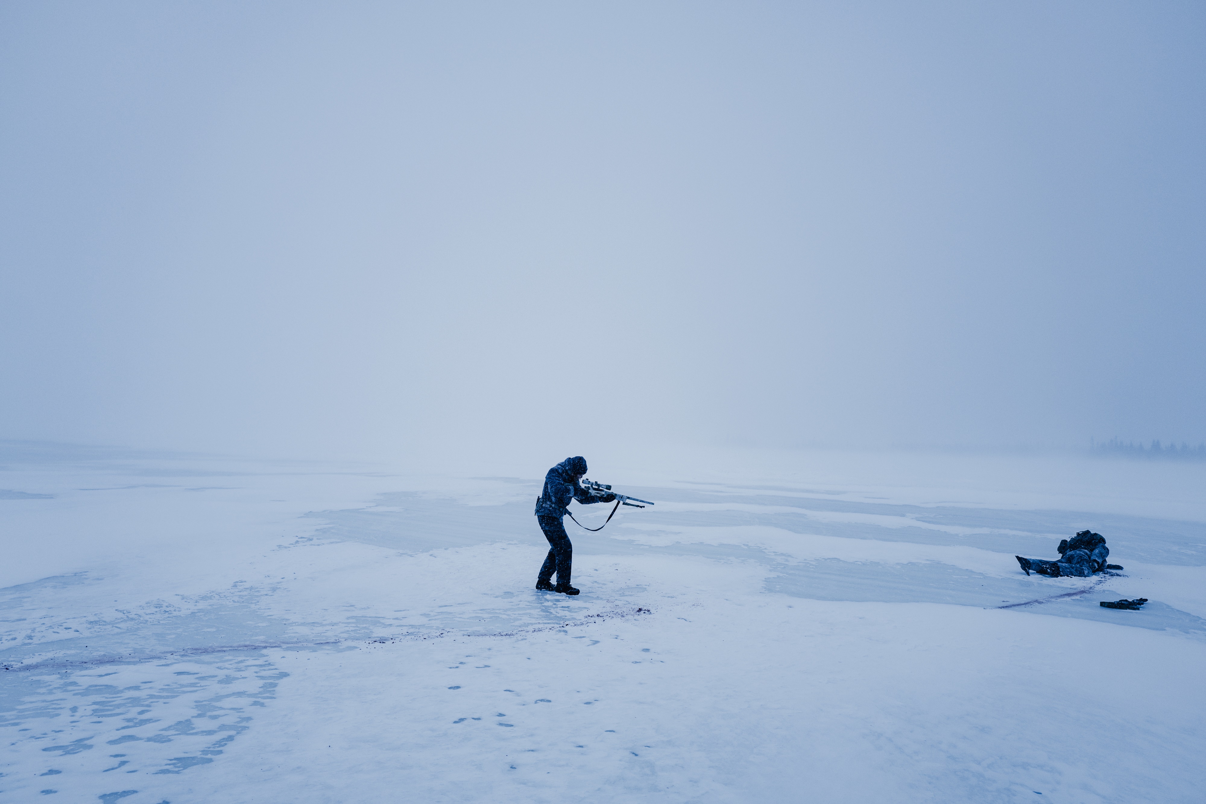 Man with rifle in snowy landscape HD Wallpaper
