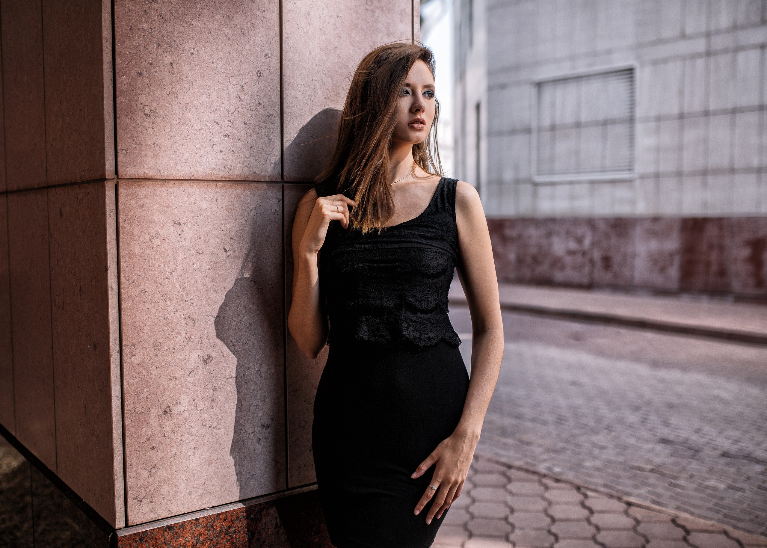 Woman in black dress leaning against a building HD Wallpaper
