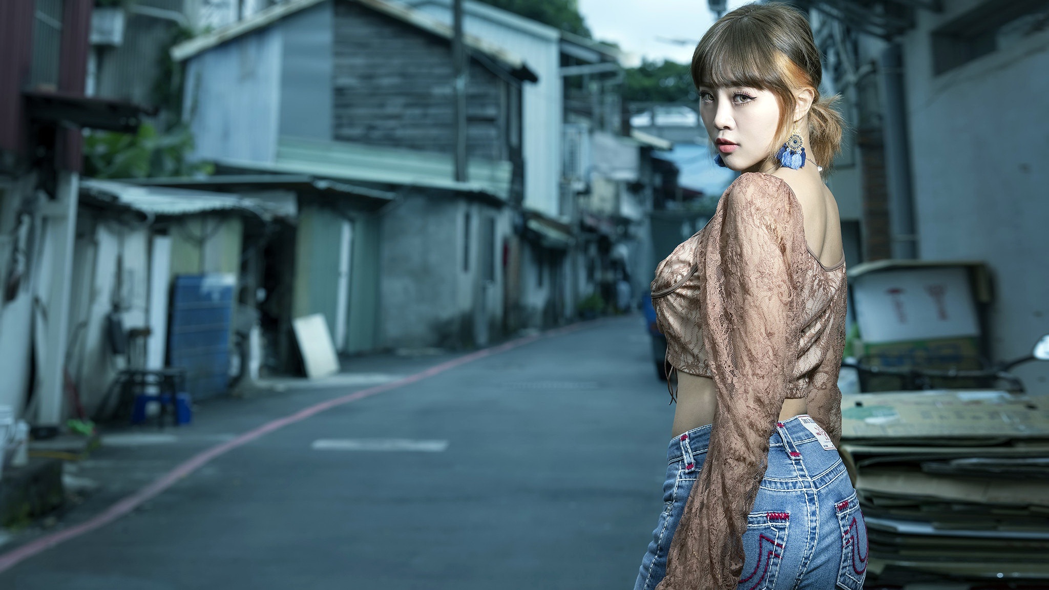 Asian woman in jeans and lace top in alley HD Wallpaper