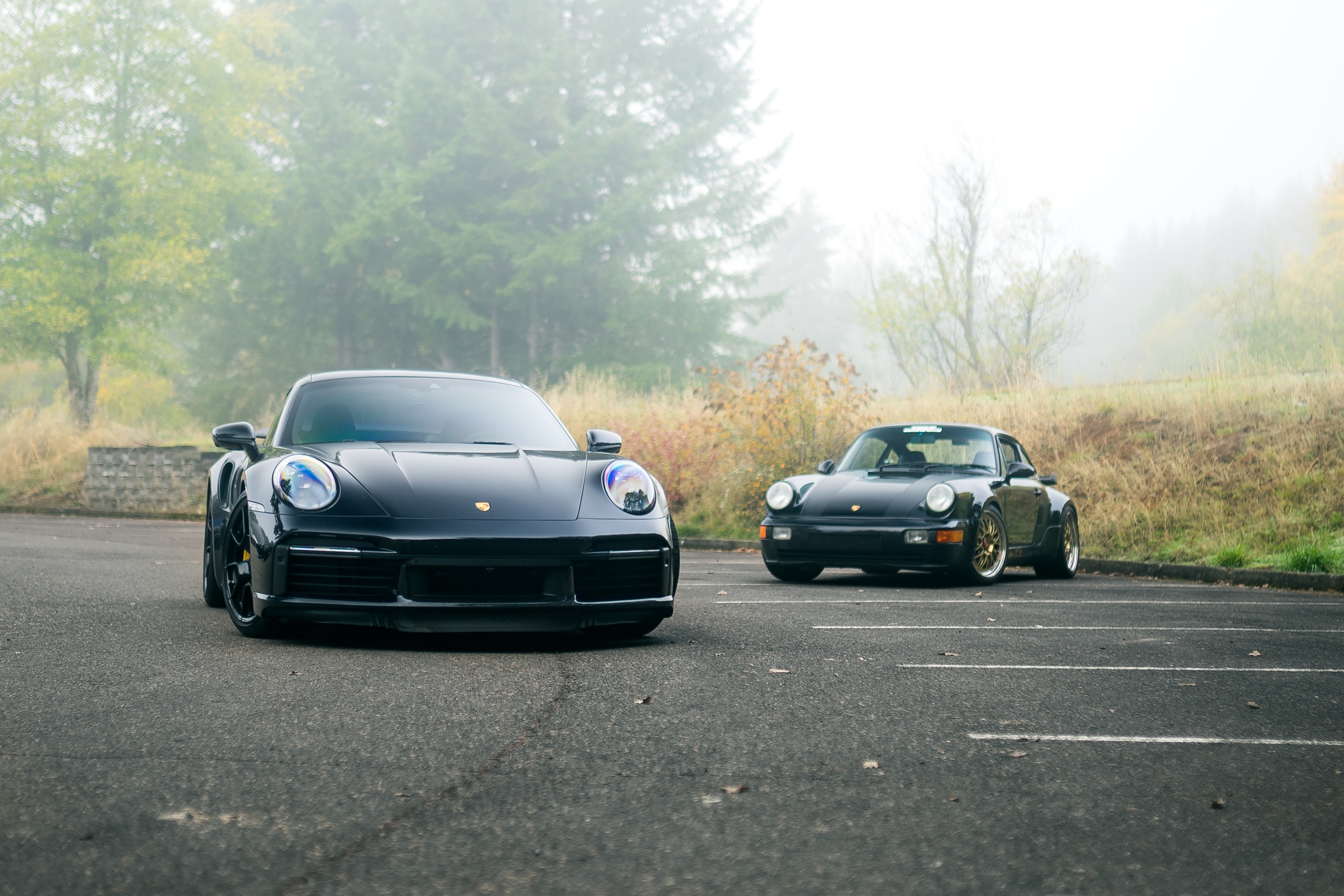 Two black Porsche 911 Turbo cars parked HD Wallpaper