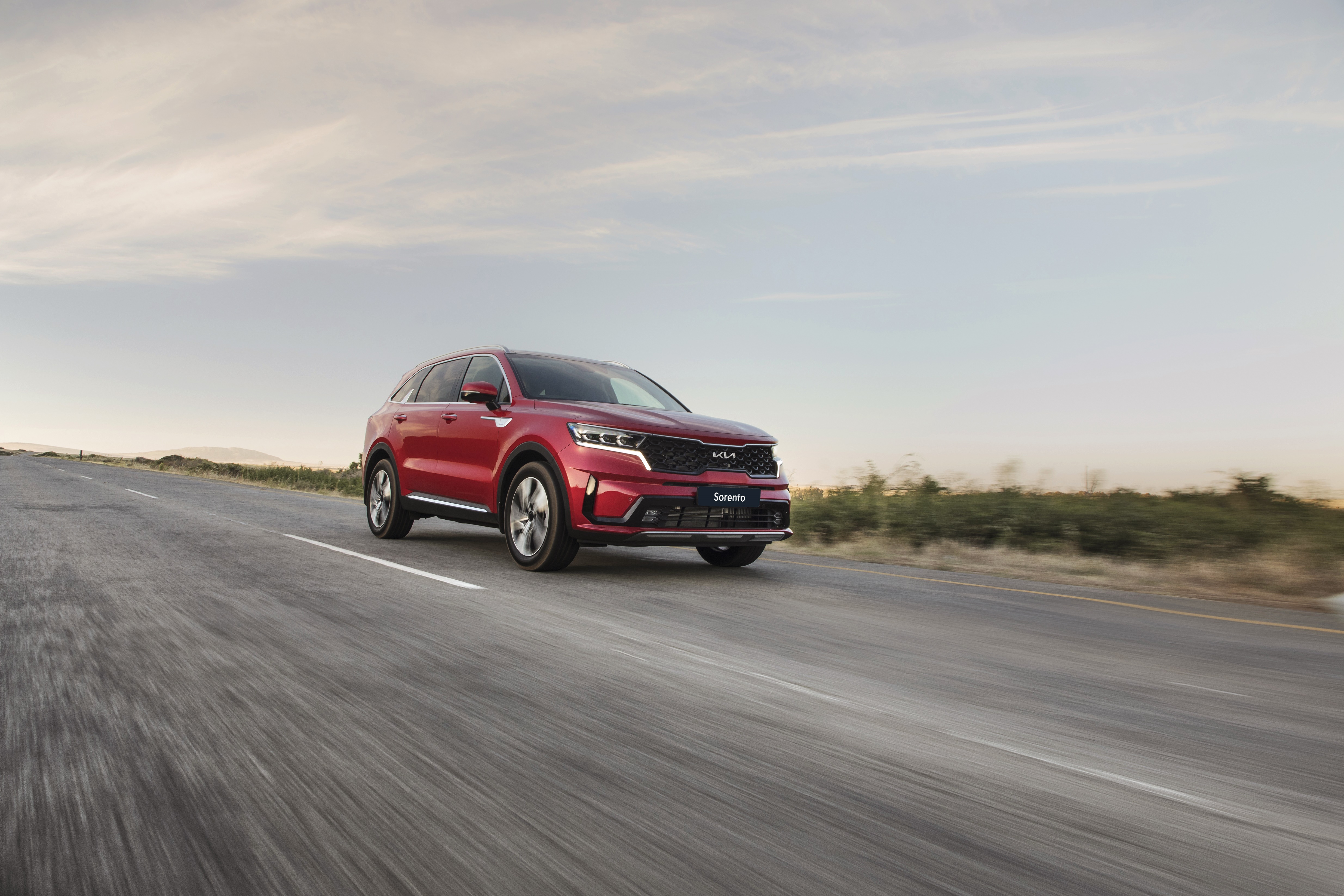Red Kia Sorento SUV driving on a road HD Wallpaper