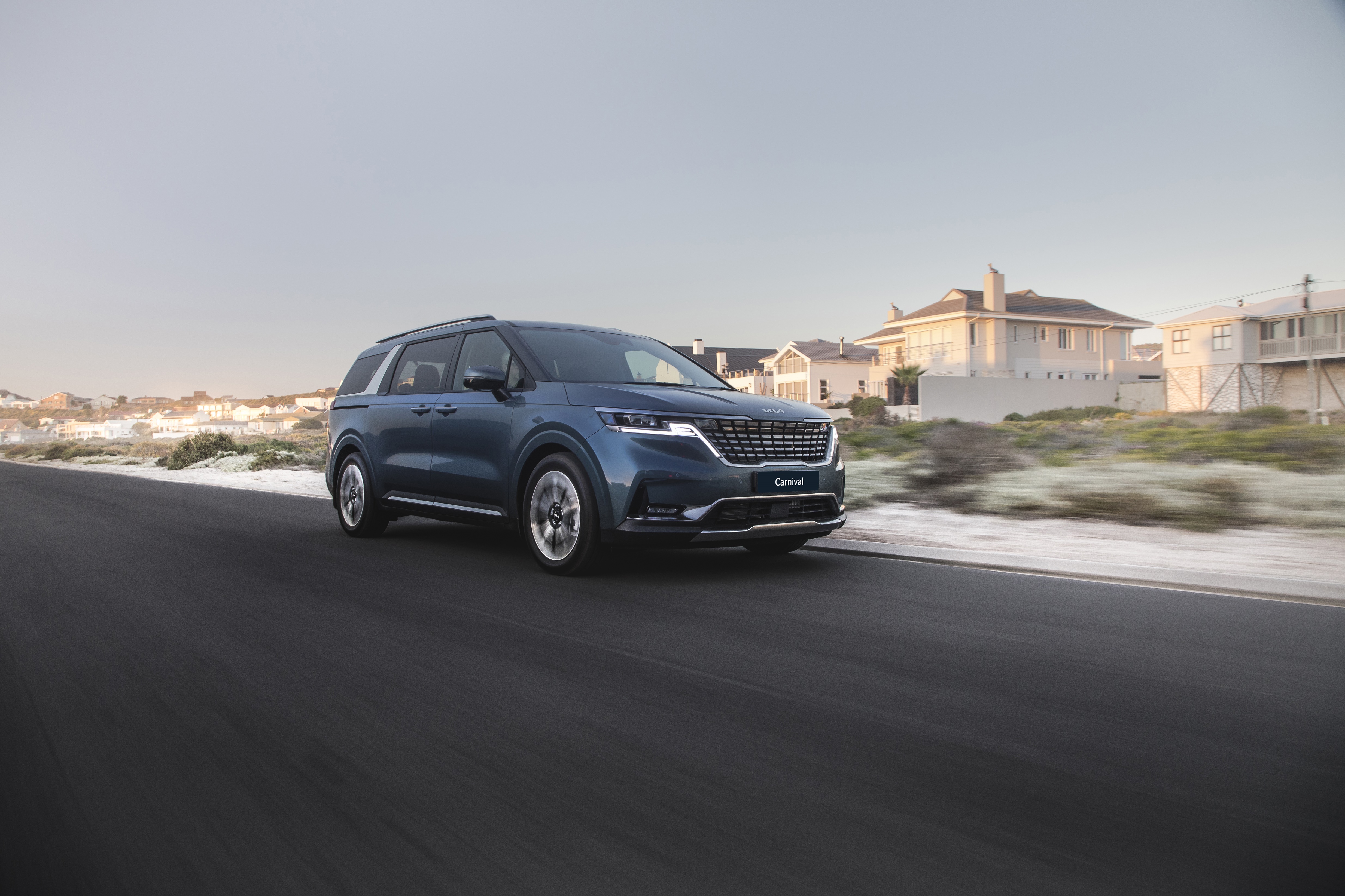 Blue Kia Carnival driving on a road HD Wallpaper