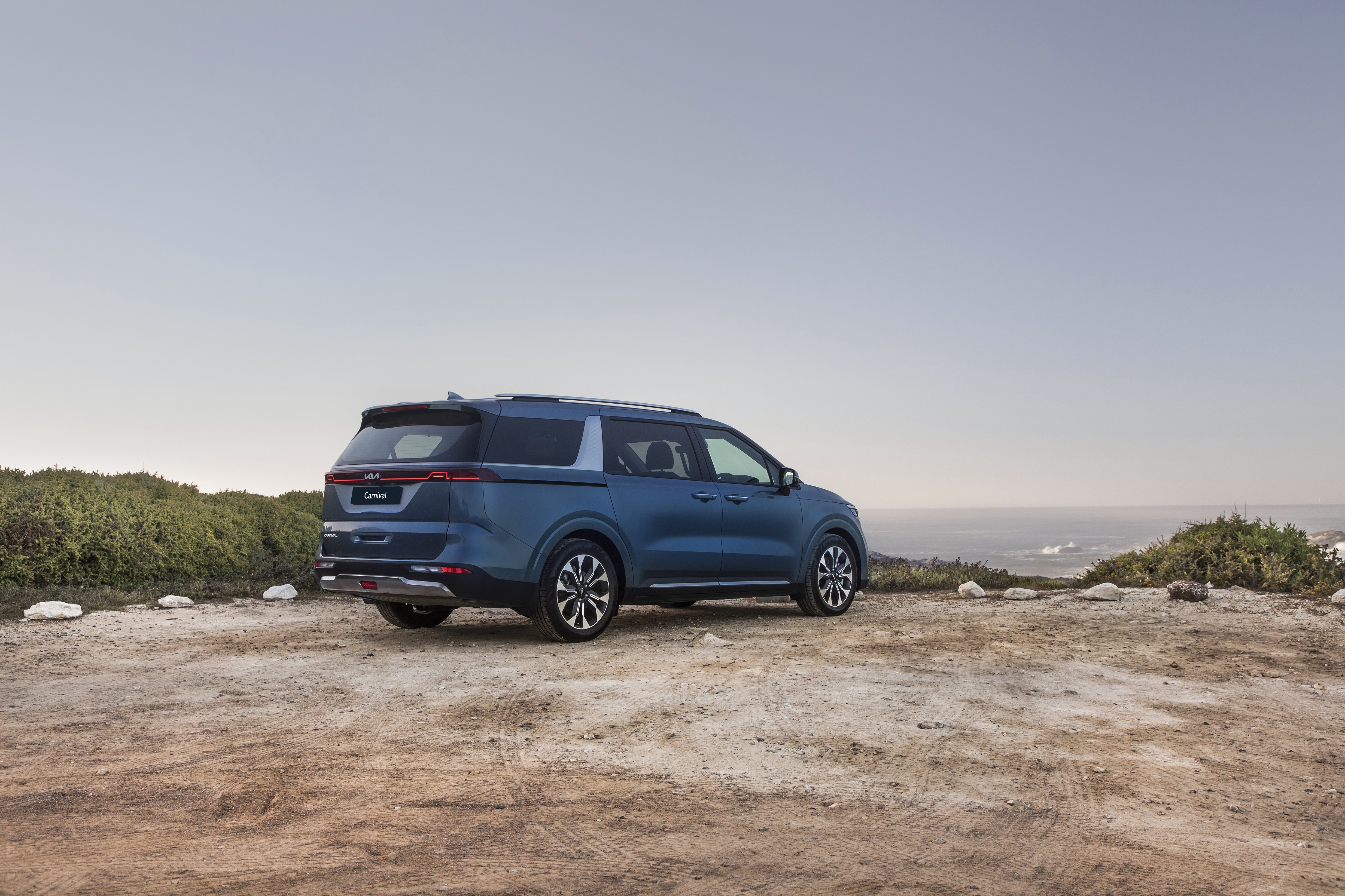 Blue Kia Carnival parked near the ocean HD Wallpaper