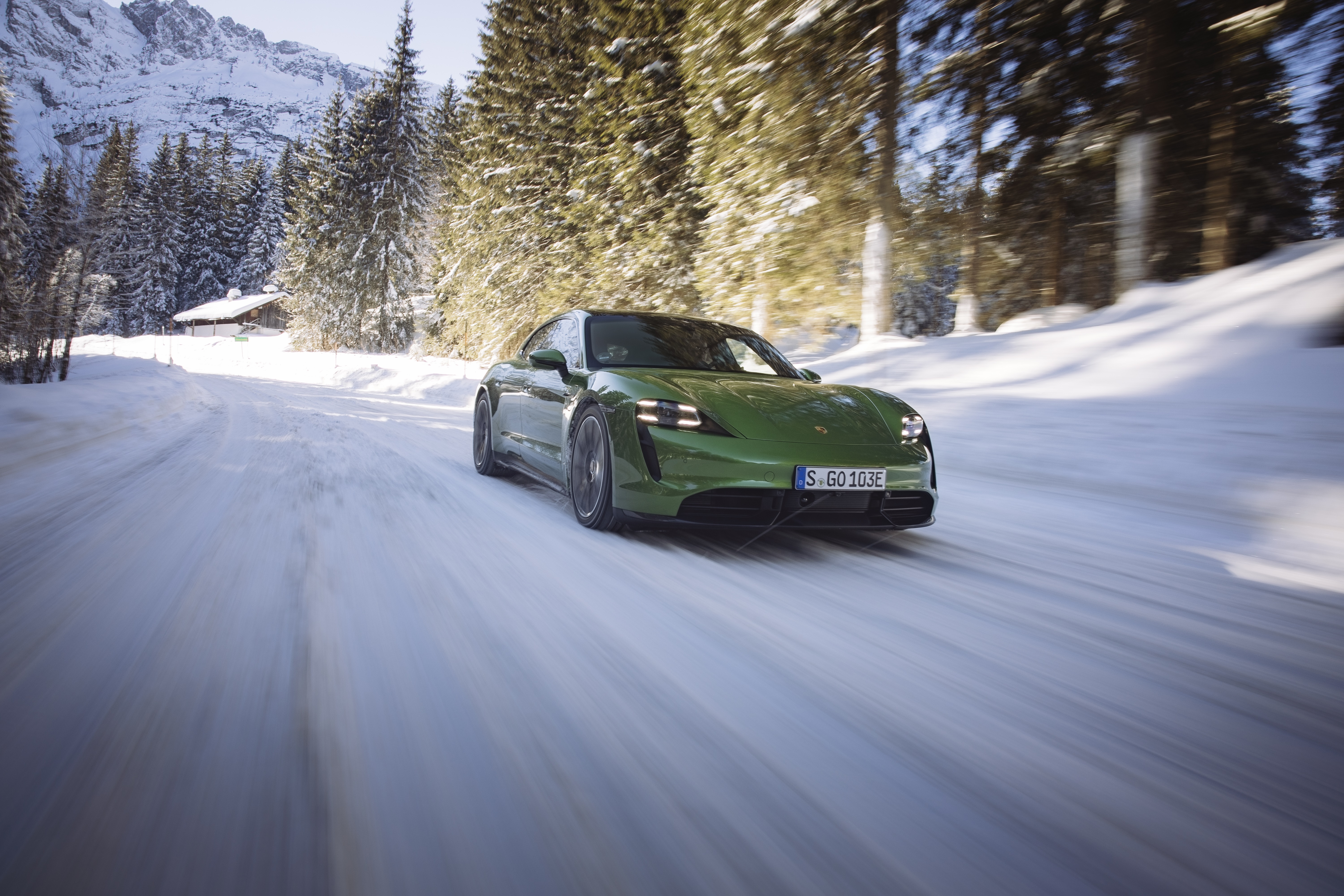 Green Porsche Taycan Turbo S driving on a snowy road HD Wallpaper