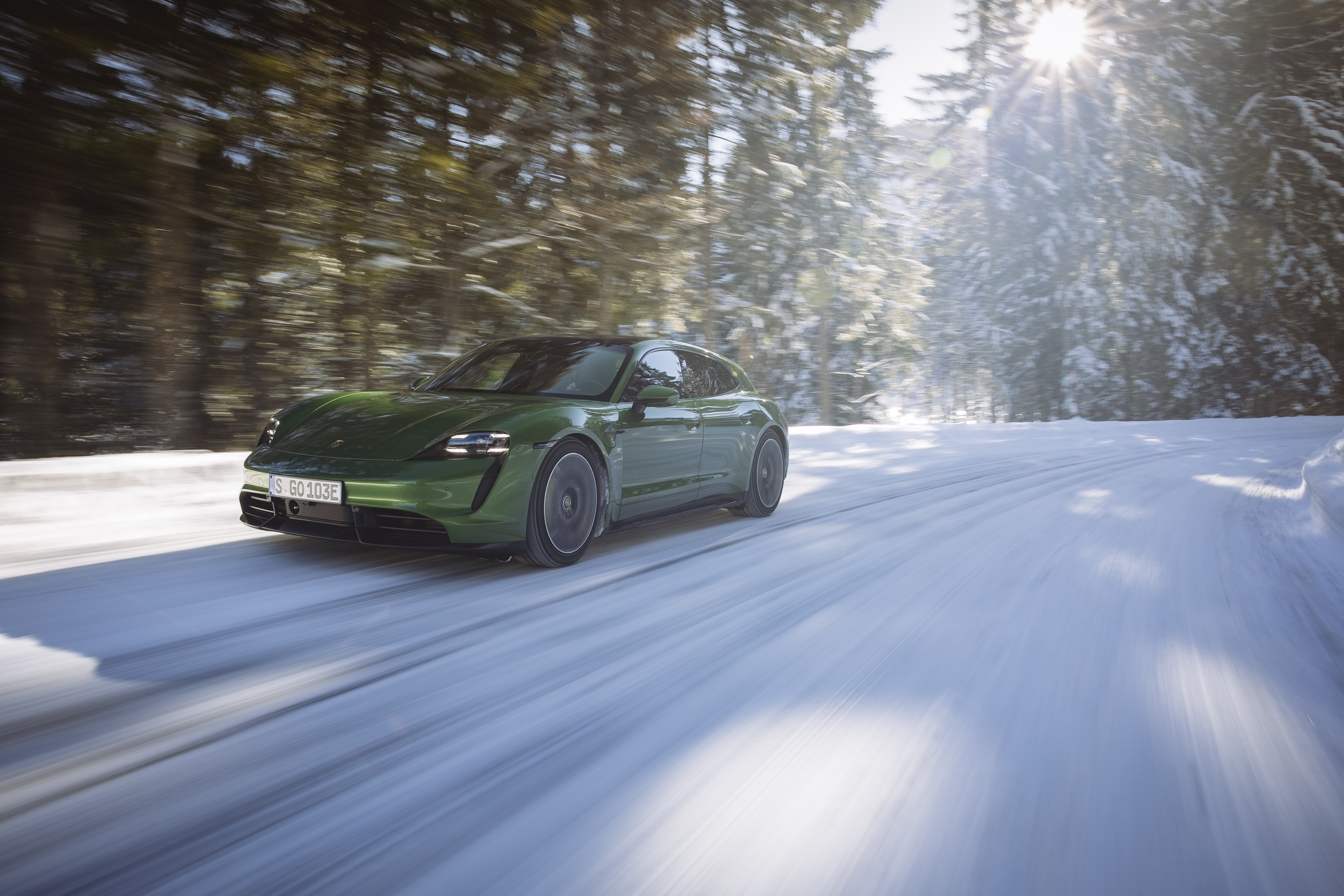 Green Porsche Taycan Turbo S driving on a snowy road HD Wallpaper
