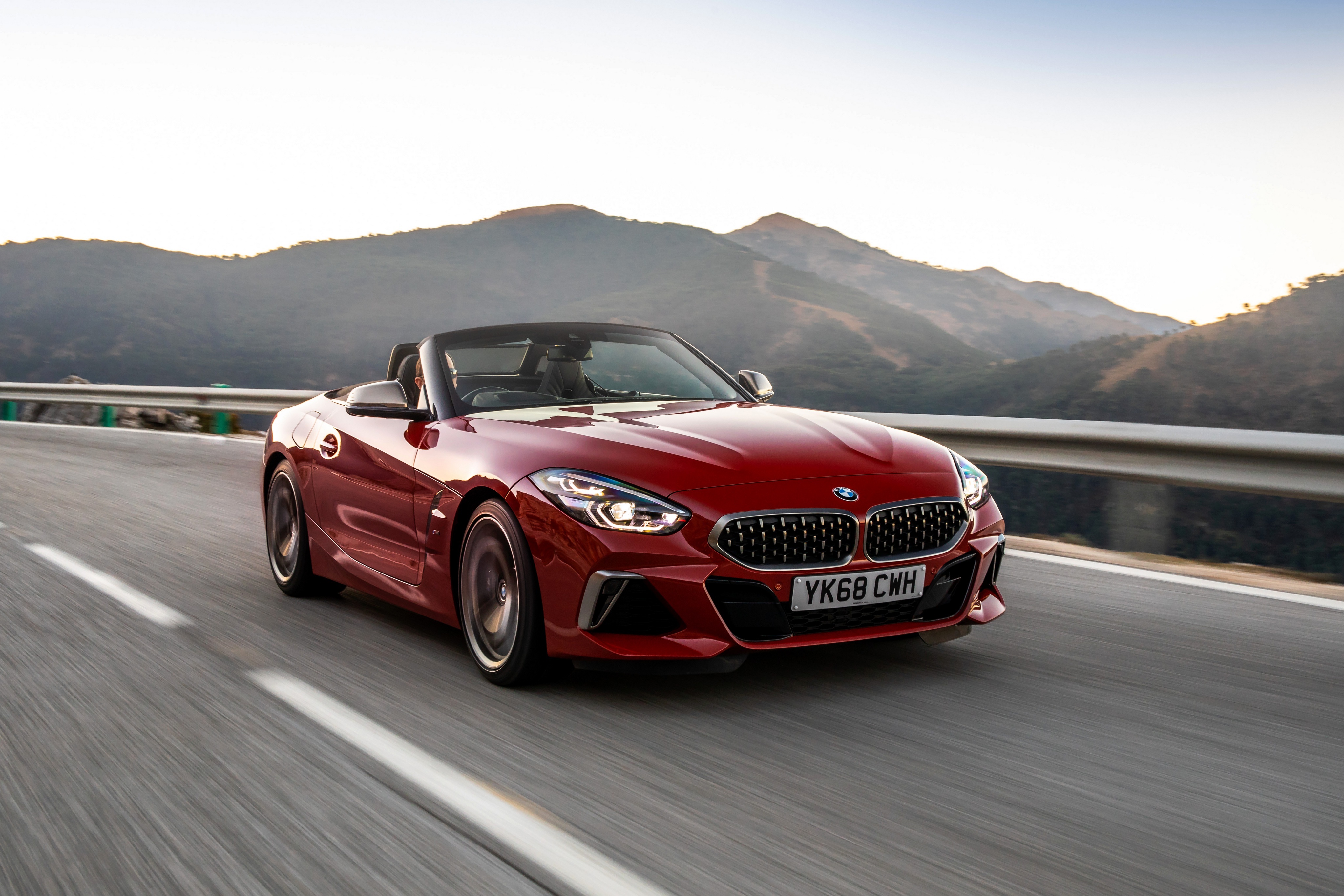 Red BMW Z4 Cabriolet driving on a mountain road HD Wallpaper