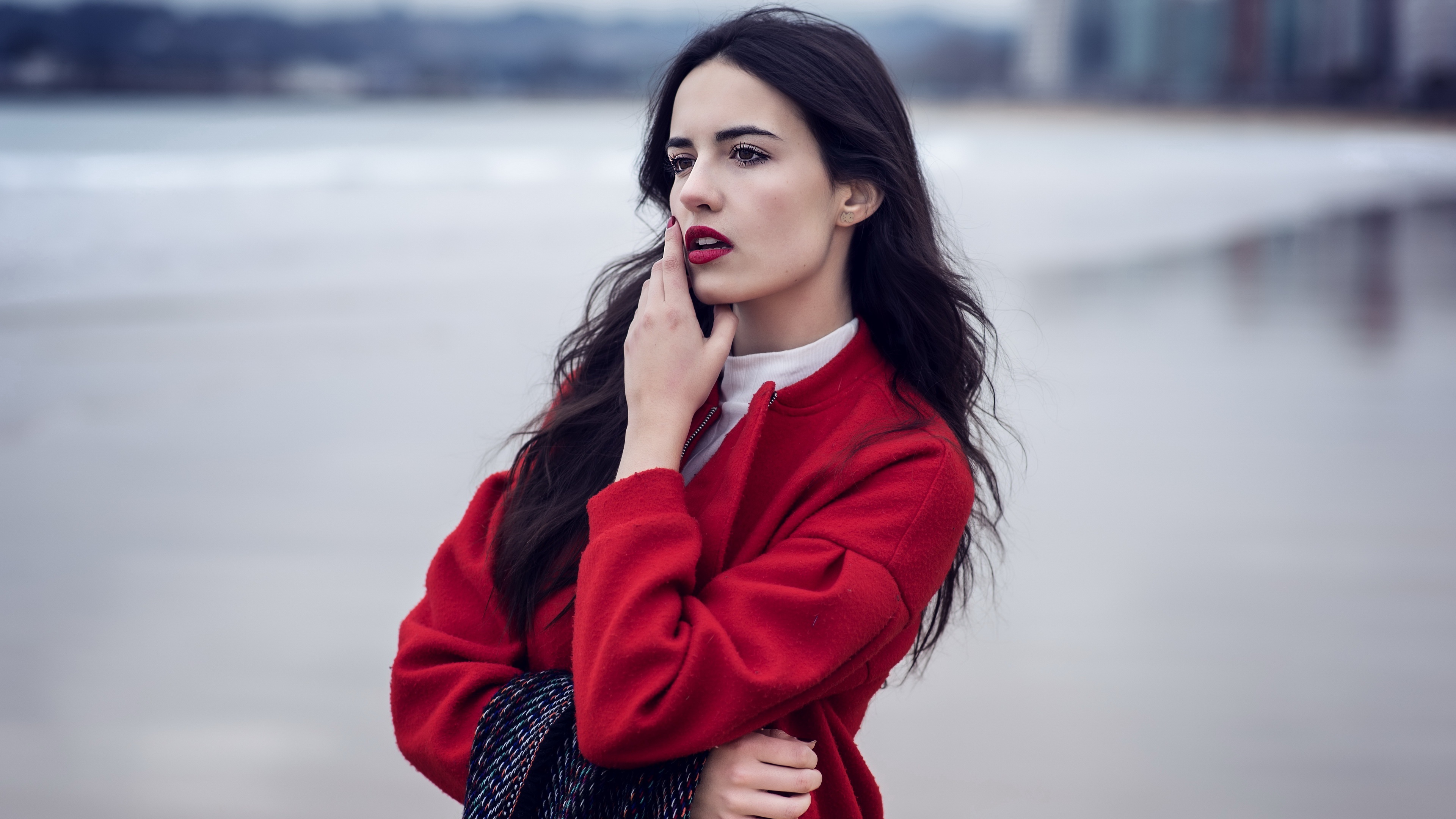 Woman with black hair in red jacket on beach HD Wallpaper