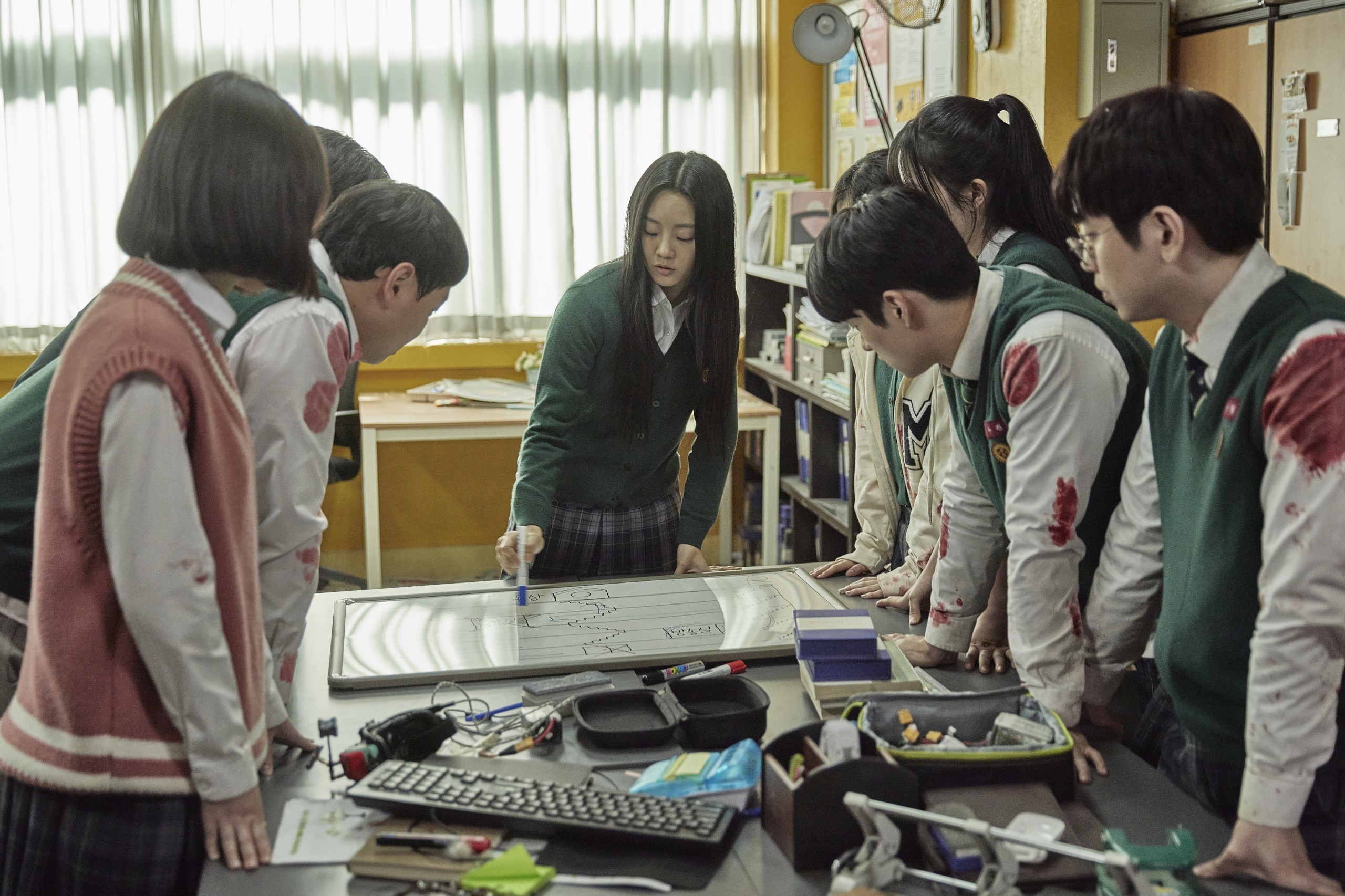 Students gathered around a whiteboard in a classroom HD Wallpaper
