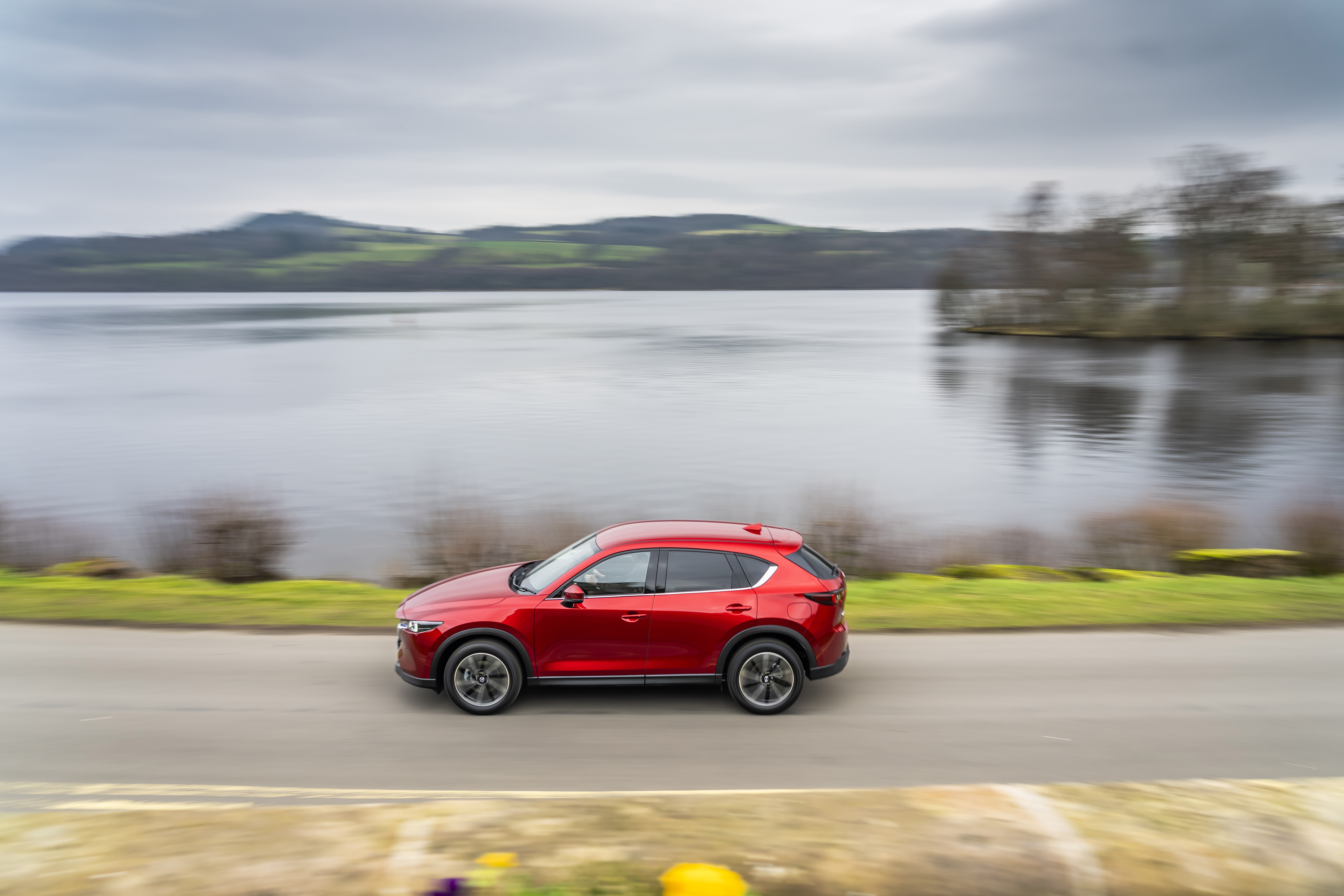 Red Mazda CX-5 SUV driving by a lake HD Wallpaper