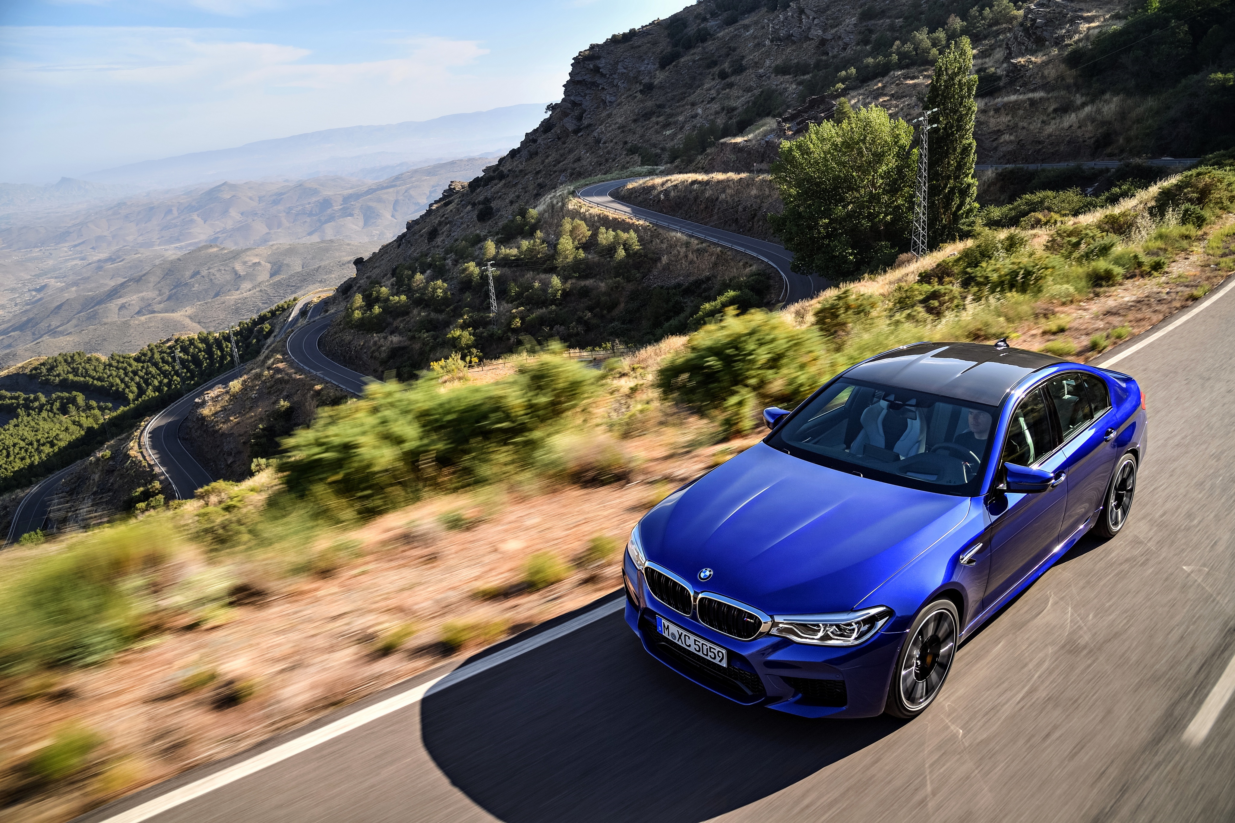 Blue BMW M5 on a winding mountain road HD Wallpaper