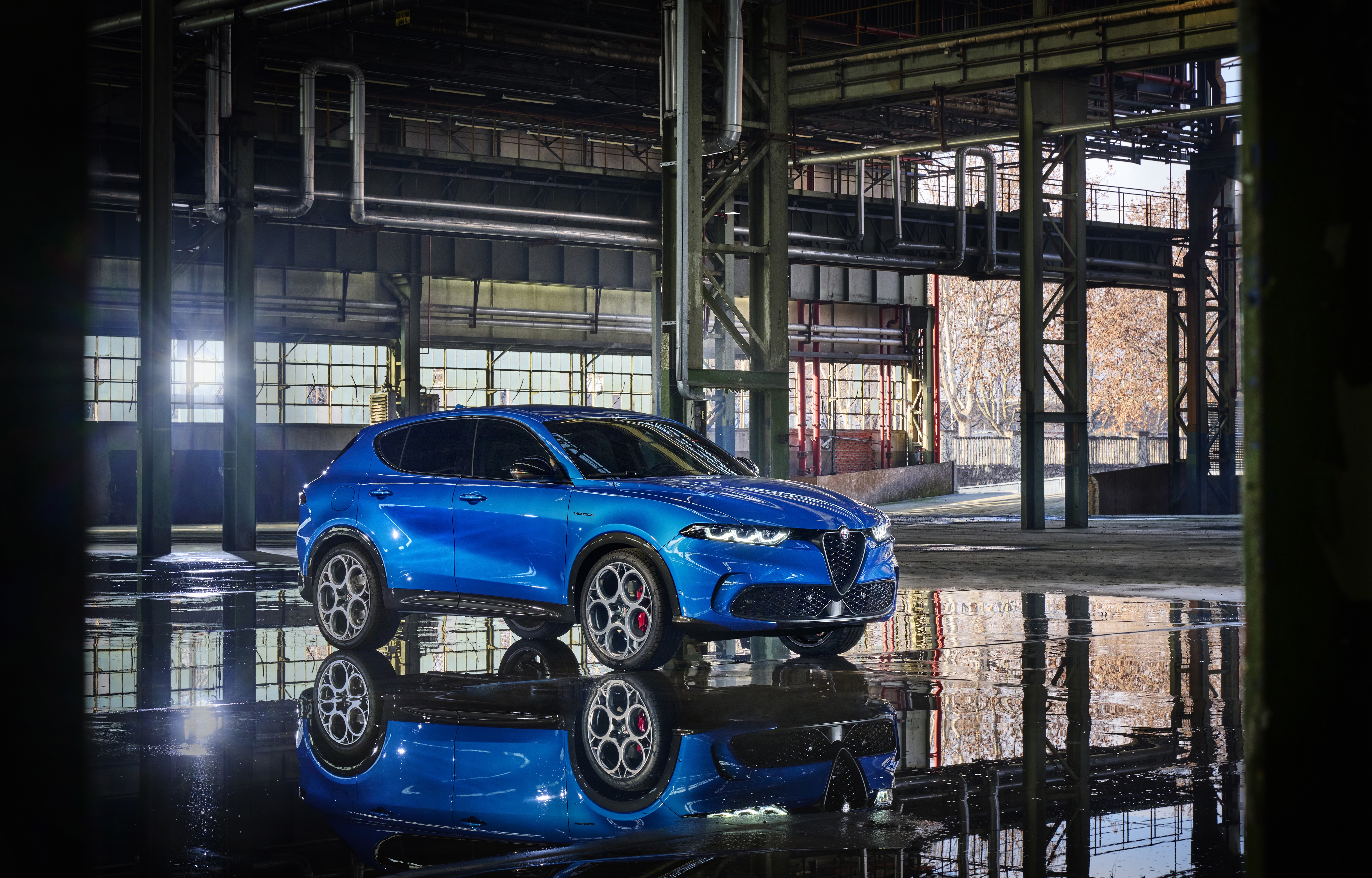 Blue Alfa Romeo Tonale SUV in industrial building HD Wallpaper