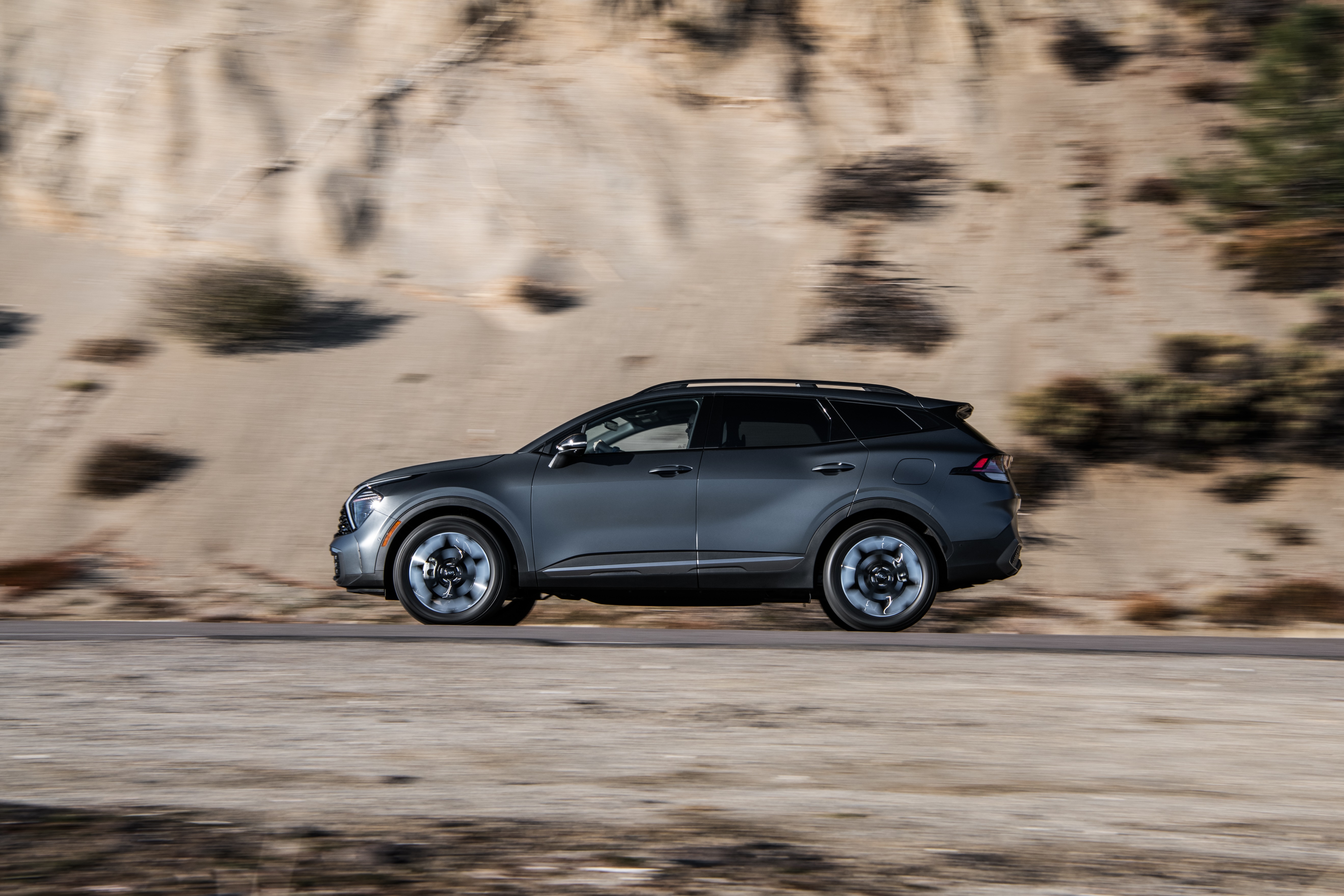 Gray Kia Sportage PHEV X-Line SUV driving on a road HD Wallpaper