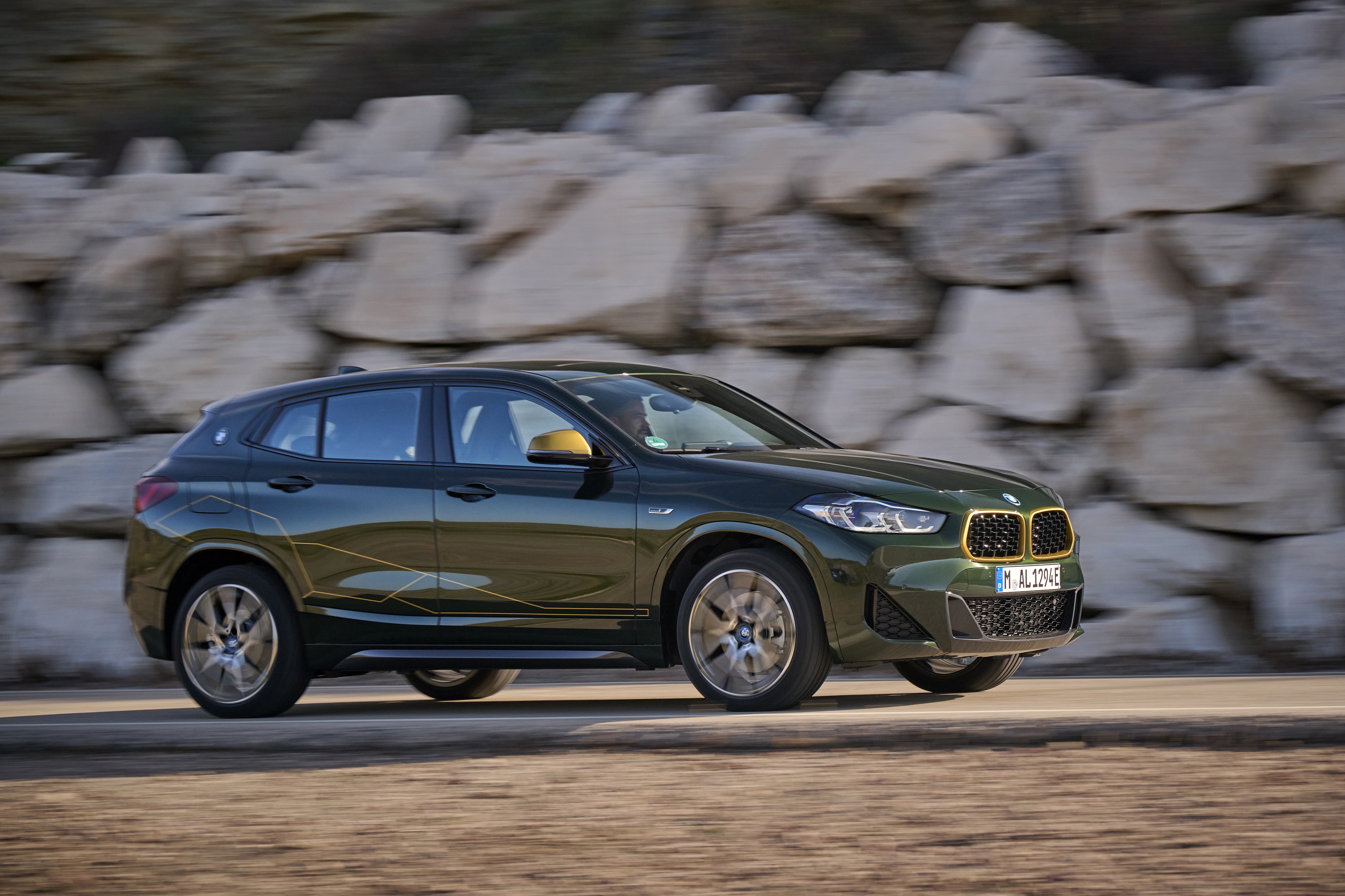 BMW X2 xDrive25e driving on a rocky road HD Wallpaper